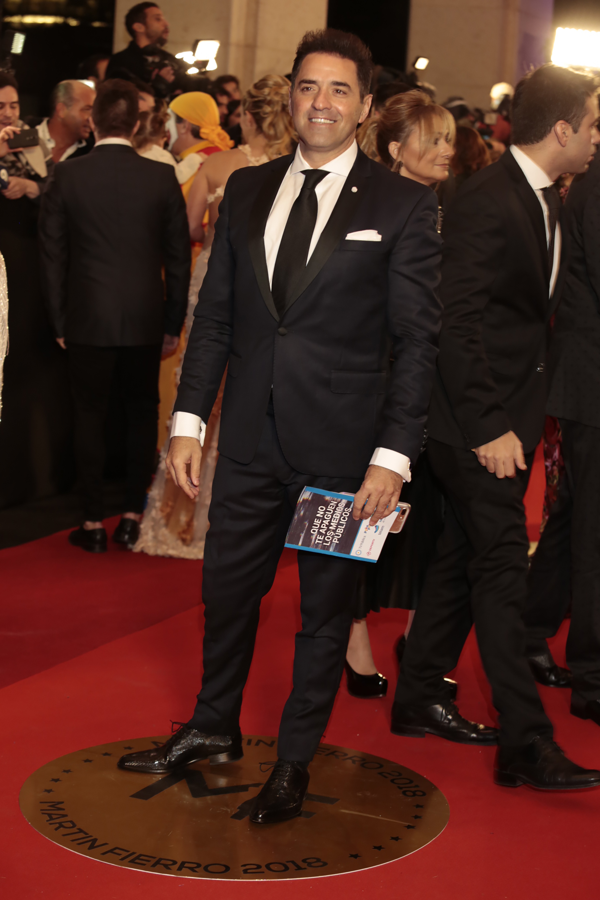 Mariano Iúdica, ganador por “Polémica en el Bar” con un clásico black tie de solapas de raso con corbata negra, camisa blanca con gemelos y zapatos abotinados de cuero negro.