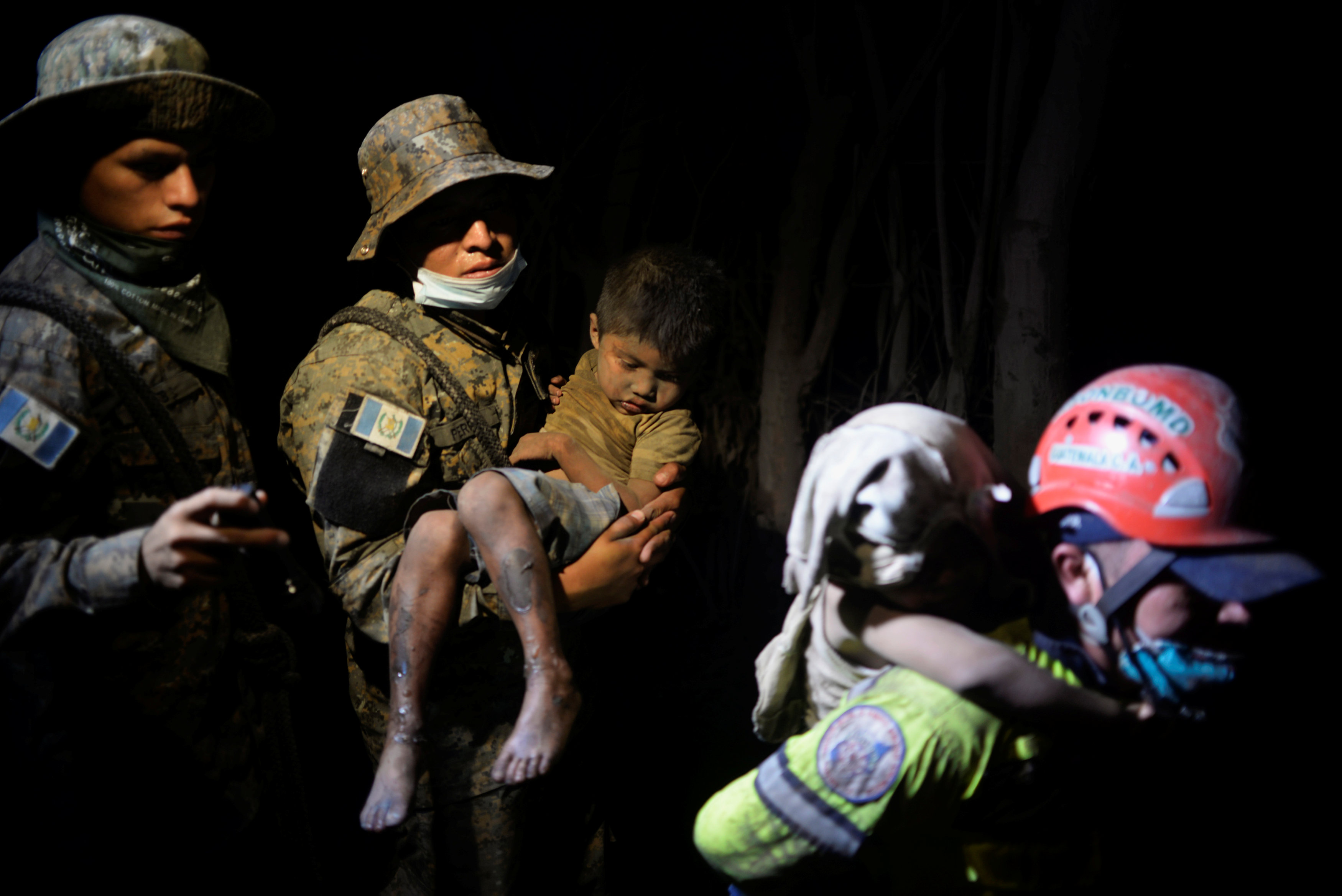 Un niño cubierto de cenizas es rescatado en EL Rodeo (REUTERS/Fabricio Alonzo)
