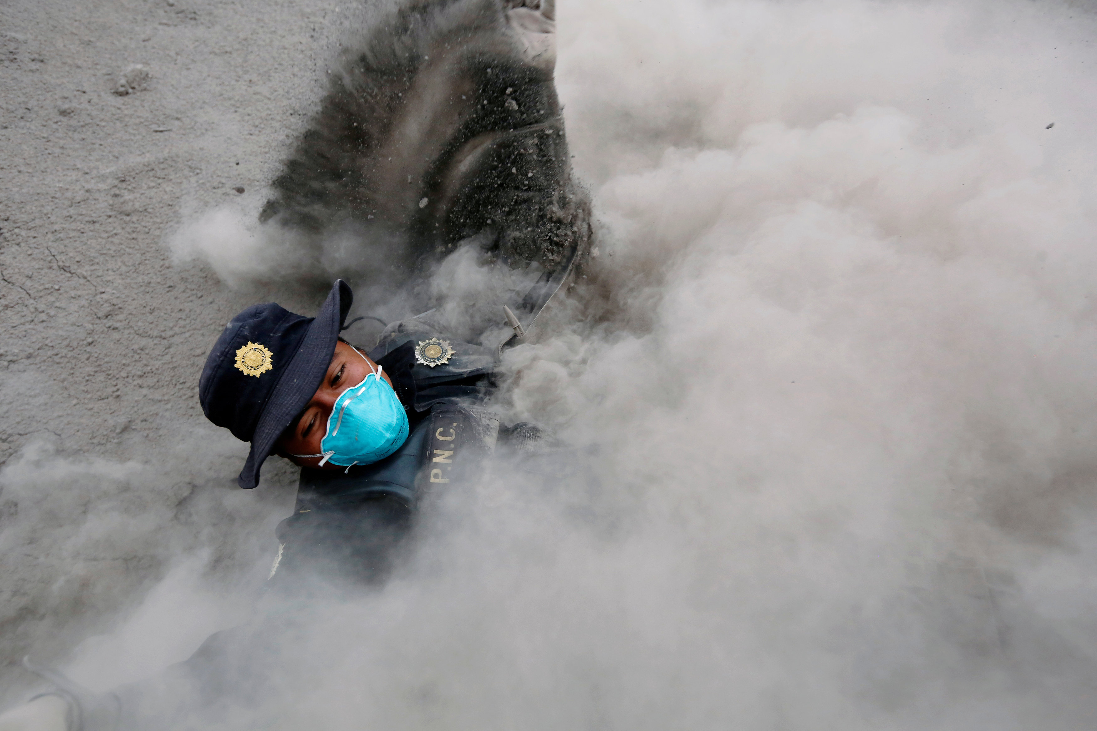 Un policía cae mientras escapa de una nueva expulsión de flujo piroclástico (Reuters/ Luis Echeverria)