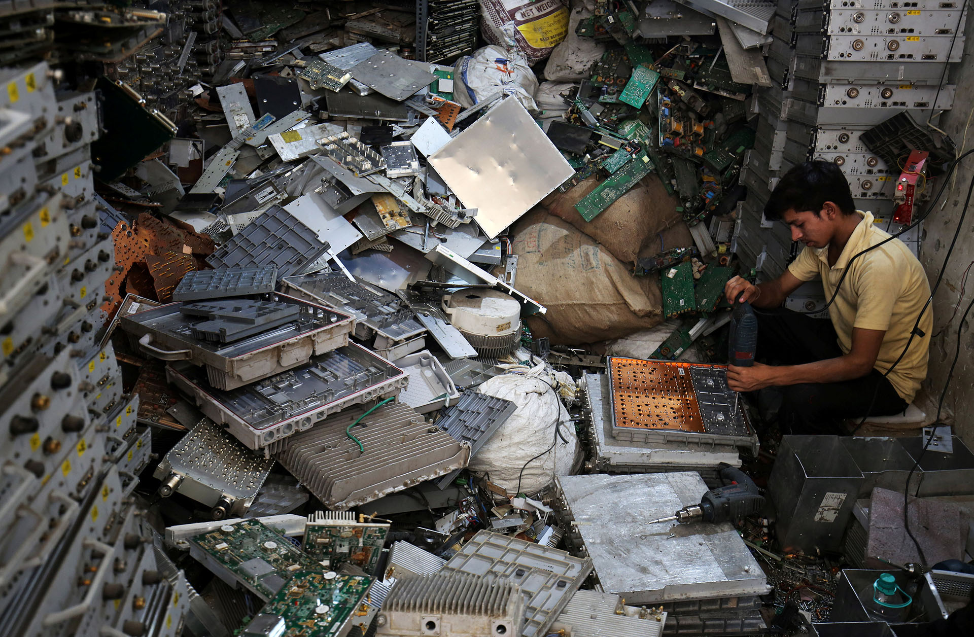 Un trabajador desarma basura electrónica en un taller en Nueva Delhi, India (REUTERS/Amit Dave)