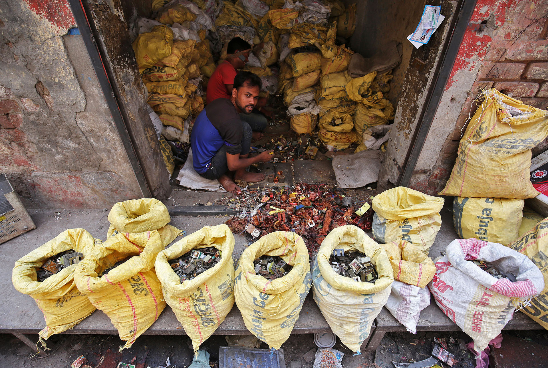 TRabajadores desarmando piezas de basura electrónica en un taller de Nueva Delhi, India (REUTERS/Amit Dave)