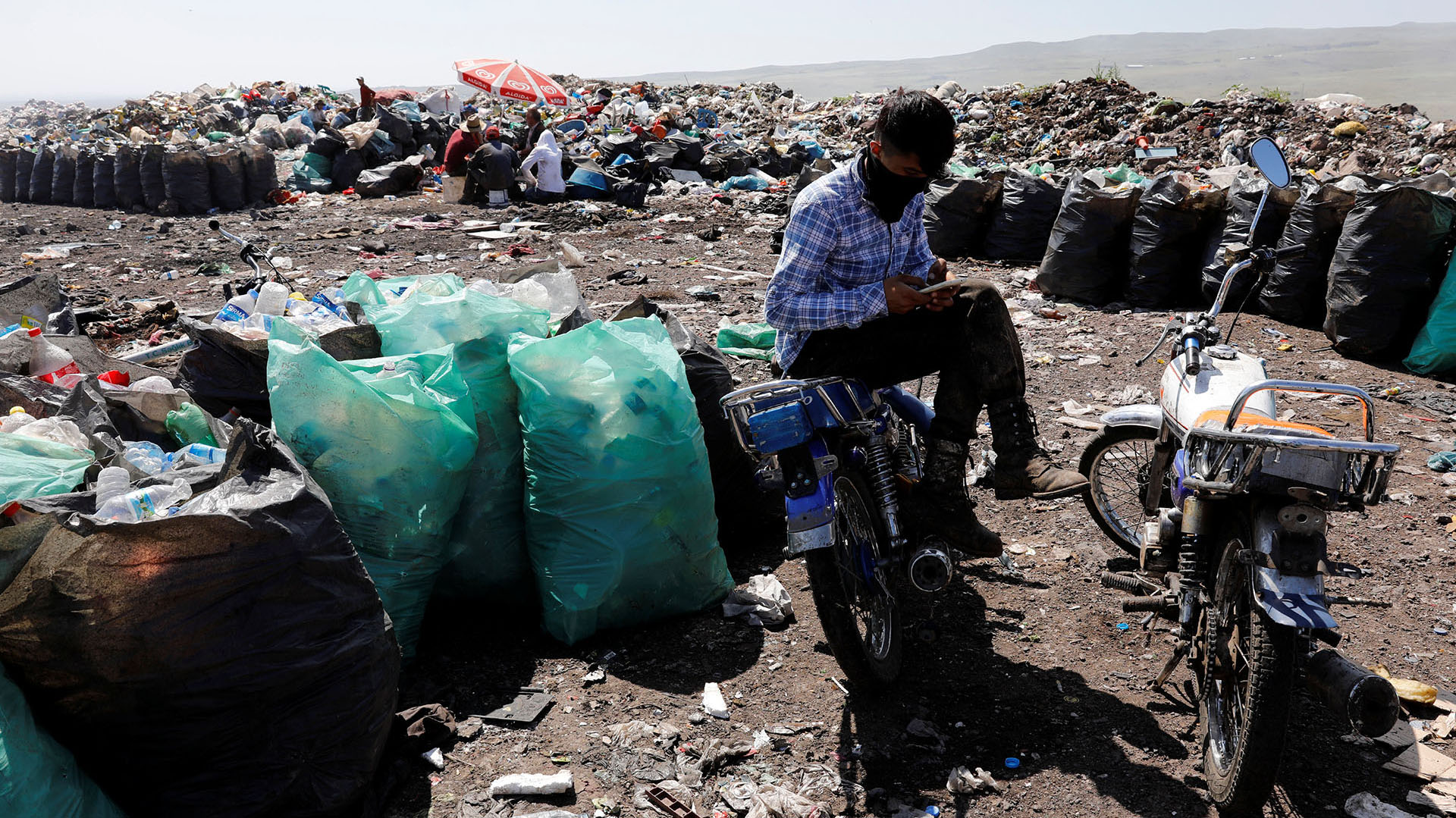 Un recolector de basura descansa en su bicicleta en un vertedero de Diyarbakir, Turquía (REUTERS/Umit Bektas)