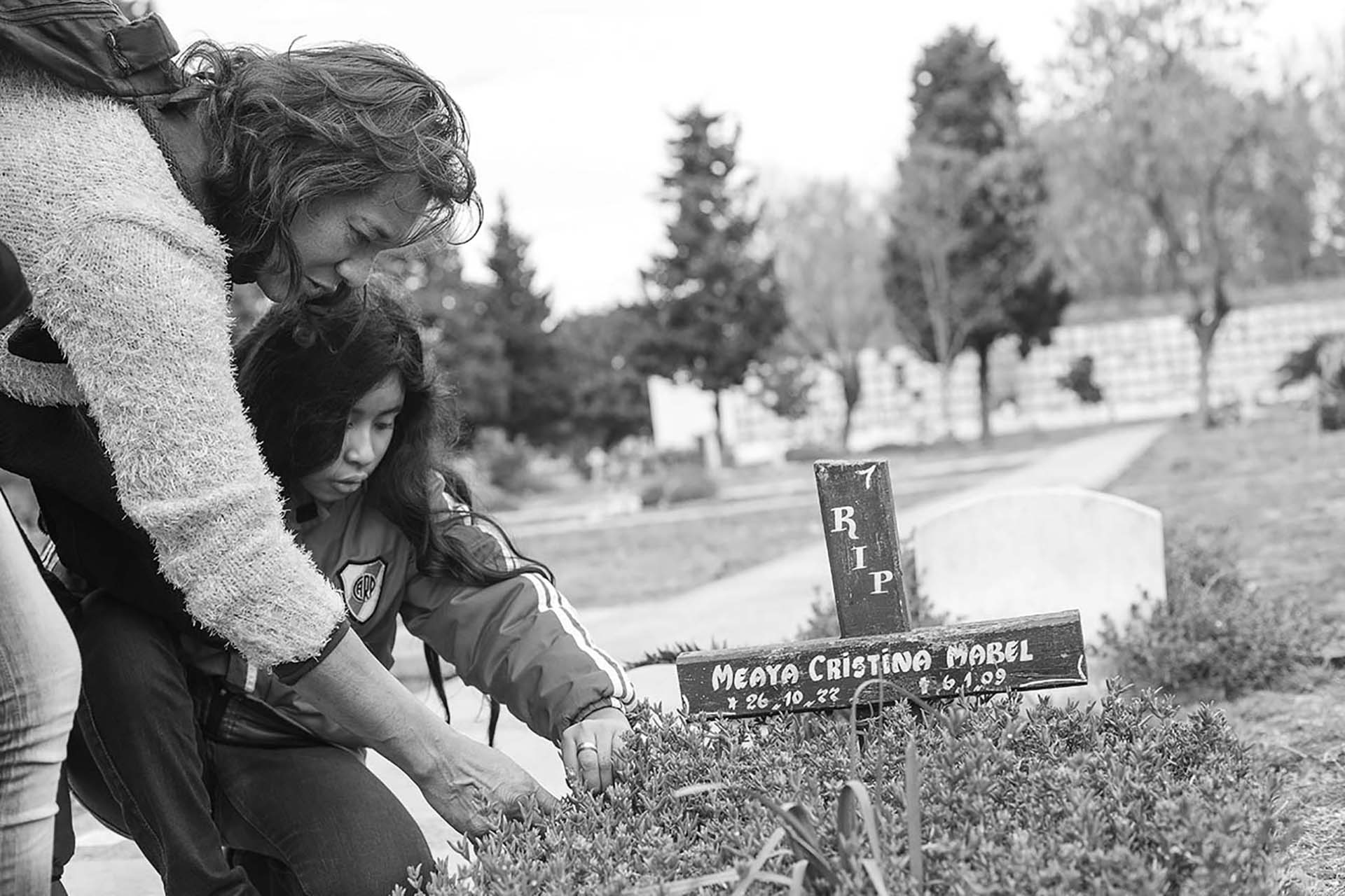 Cinthia y Zamira en el Cementerio de Chacarita, junto a la tumba de Cristina Mabel, quien fue su pareja y madre de las niñas