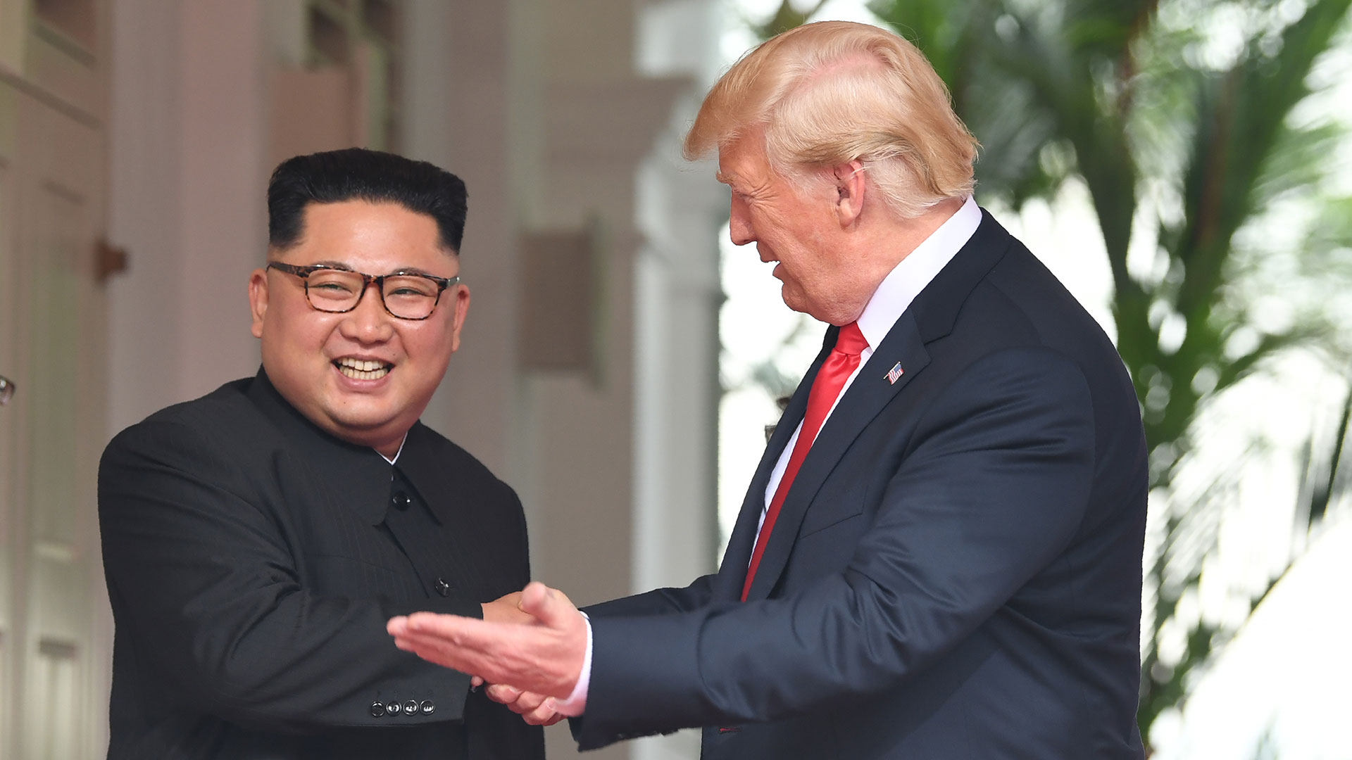 Kim Jong-un saluda sonriente al presidente estadounidense. (AFP)