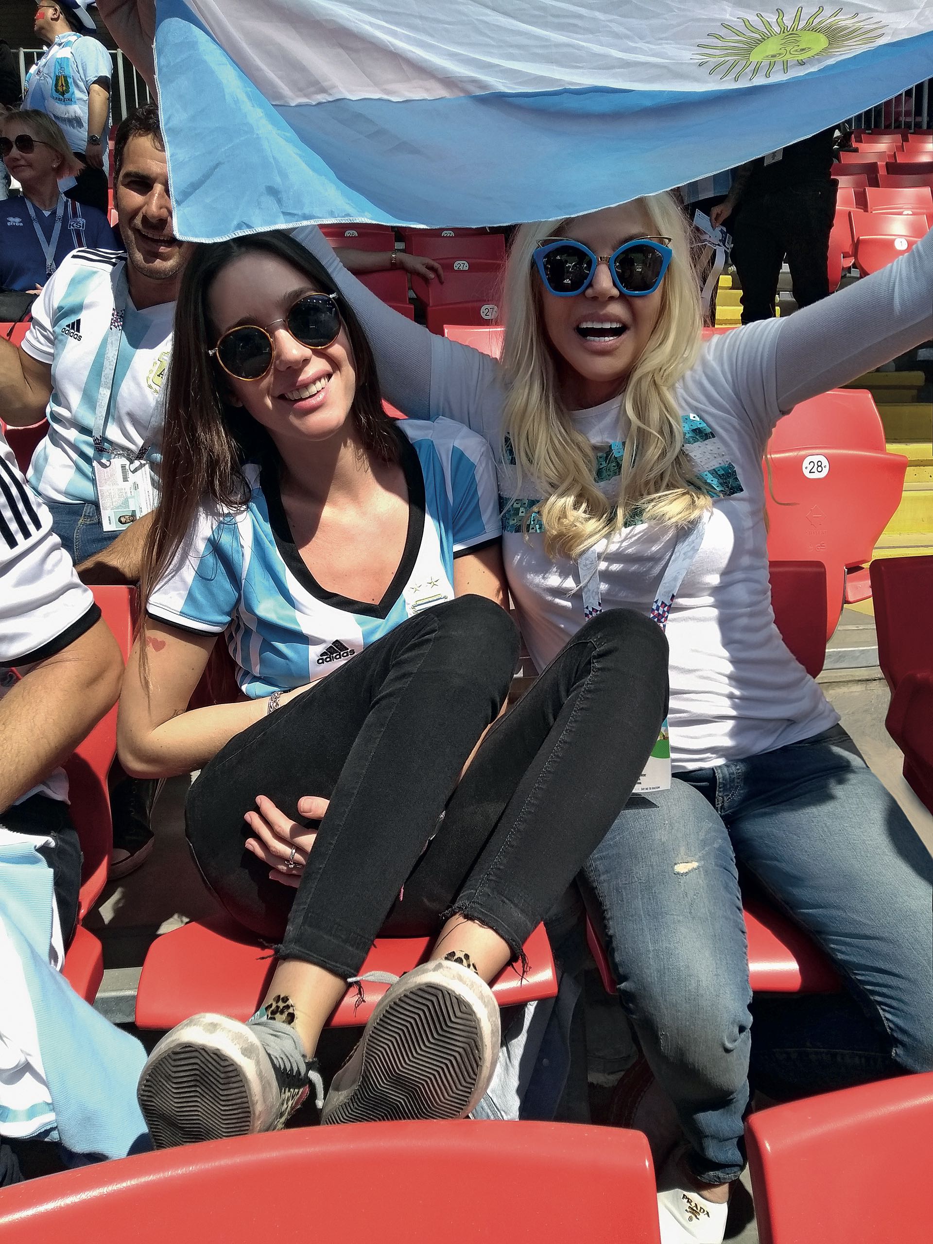 Lucía Celasco y Susana se protegen del sol con la bandera argentina.
