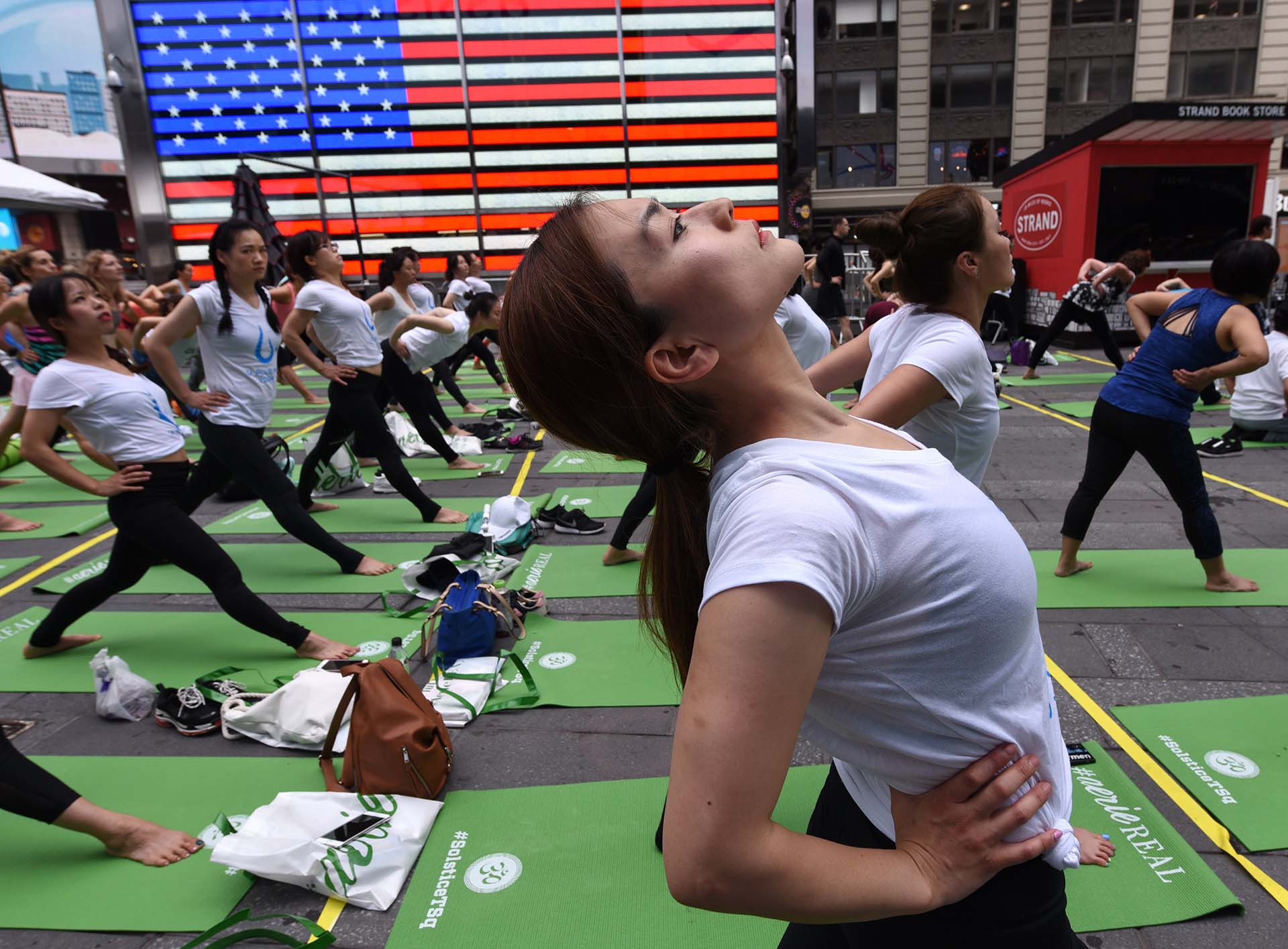 Thousands of people participate in “Mind Over Madness Yoga”, an annual all-day outdoor yoga event during the summer solstice in Times Square on June 21, 2018 in New York. / AFP PHOTO / TIMOTHY A. CLARY