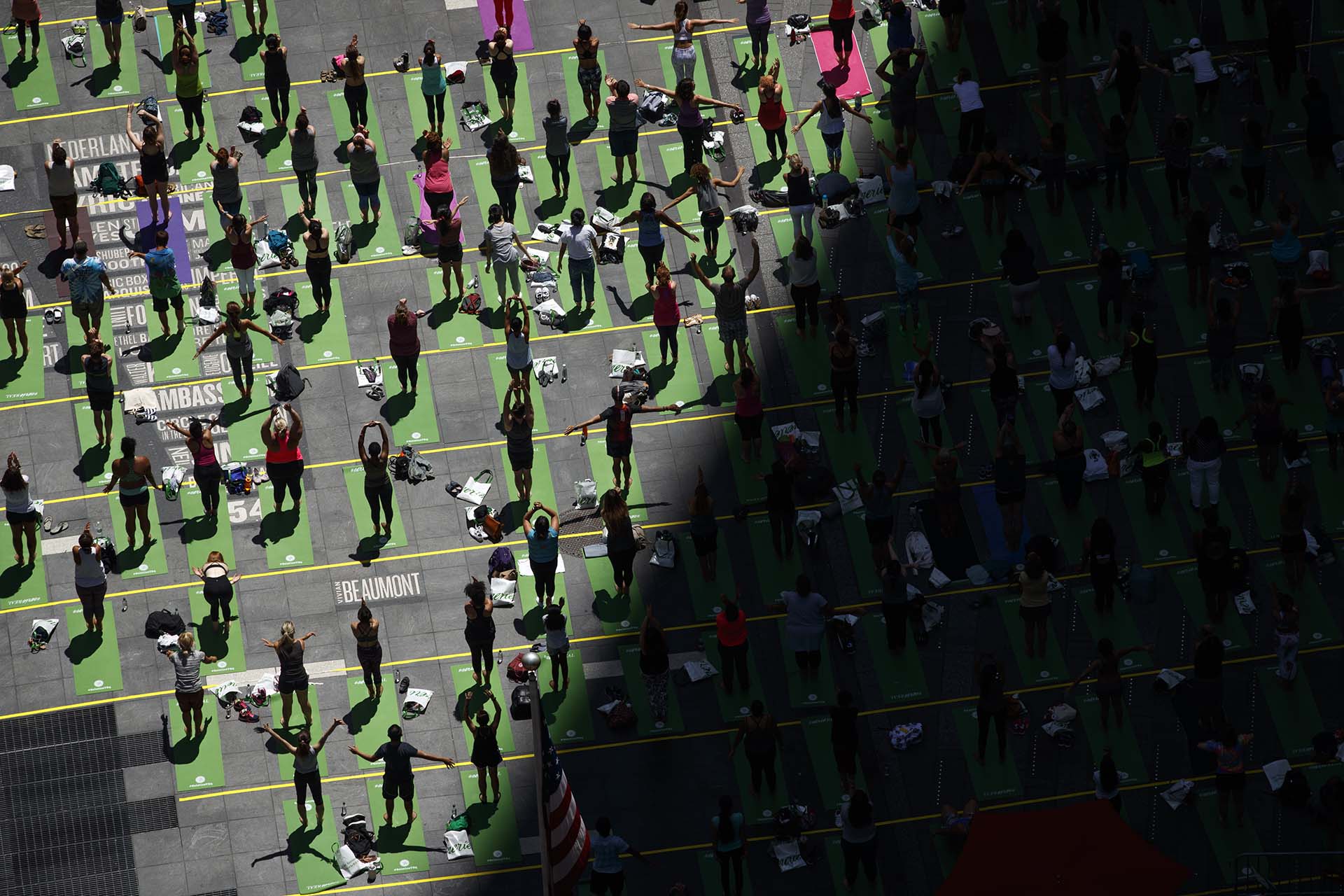 Fanáticos del yoga participan de una clase masiva al aire libre en Time Square (Drew Angerer/Getty Images/AFP)