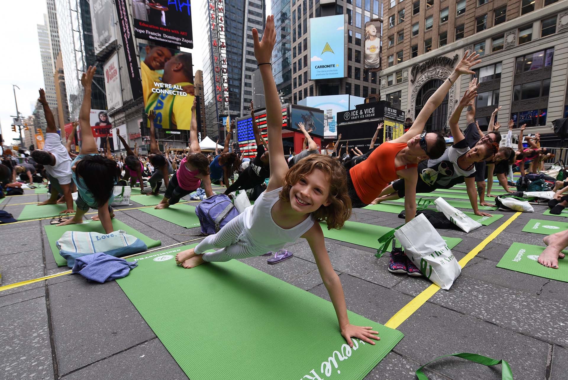 Kate Steinberg, de 9 años y oriunda de Montreal, junto a miles de personas celebrando el Día Mundial del Yoga (AFP PHOTO / TIMOTHY A. CLARY)
