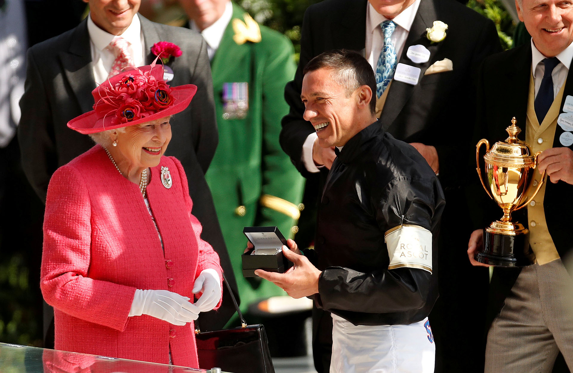 La monarca sonríe junto a uno de los ganadores, Frankie Dettori