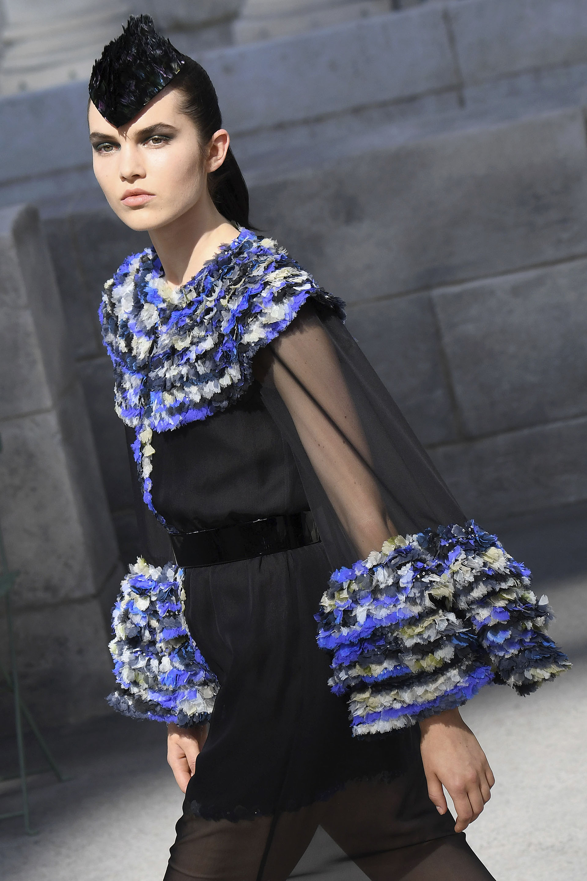 Transparencias, sedas, gasas, tweed y mix de géneros no faltaron en la pasarela de Chanel. Un diseño que combino texturas y géneros nobles coronado con un tocado pequeño de plumas.