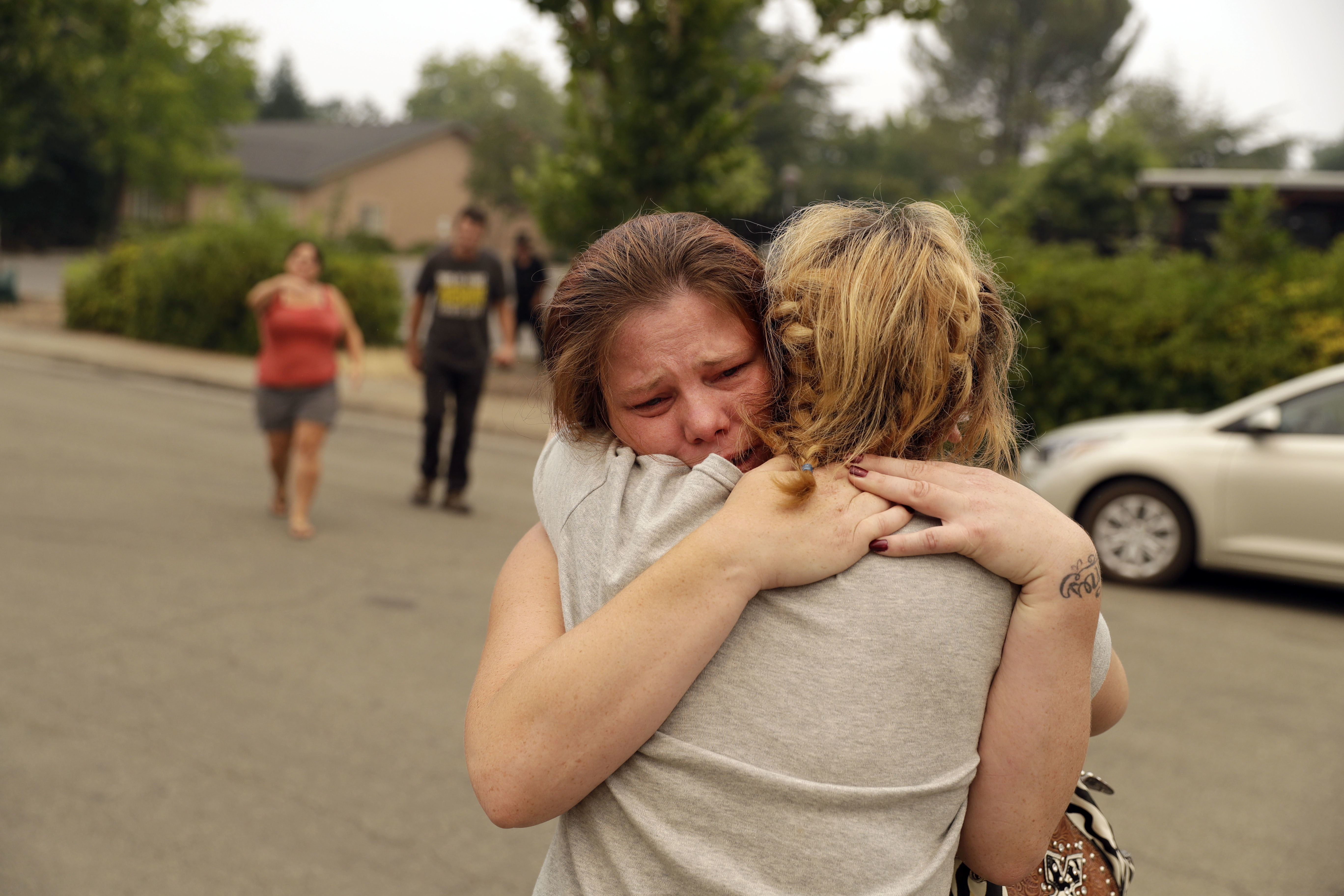 Carla Bledsoe abraza su hermana Sherry tras enterarse que los hijos de Sherry, James y Emily, murieron junto con la abuela durante el incendio el sábado (AP/Marcio Jose Sanchez)