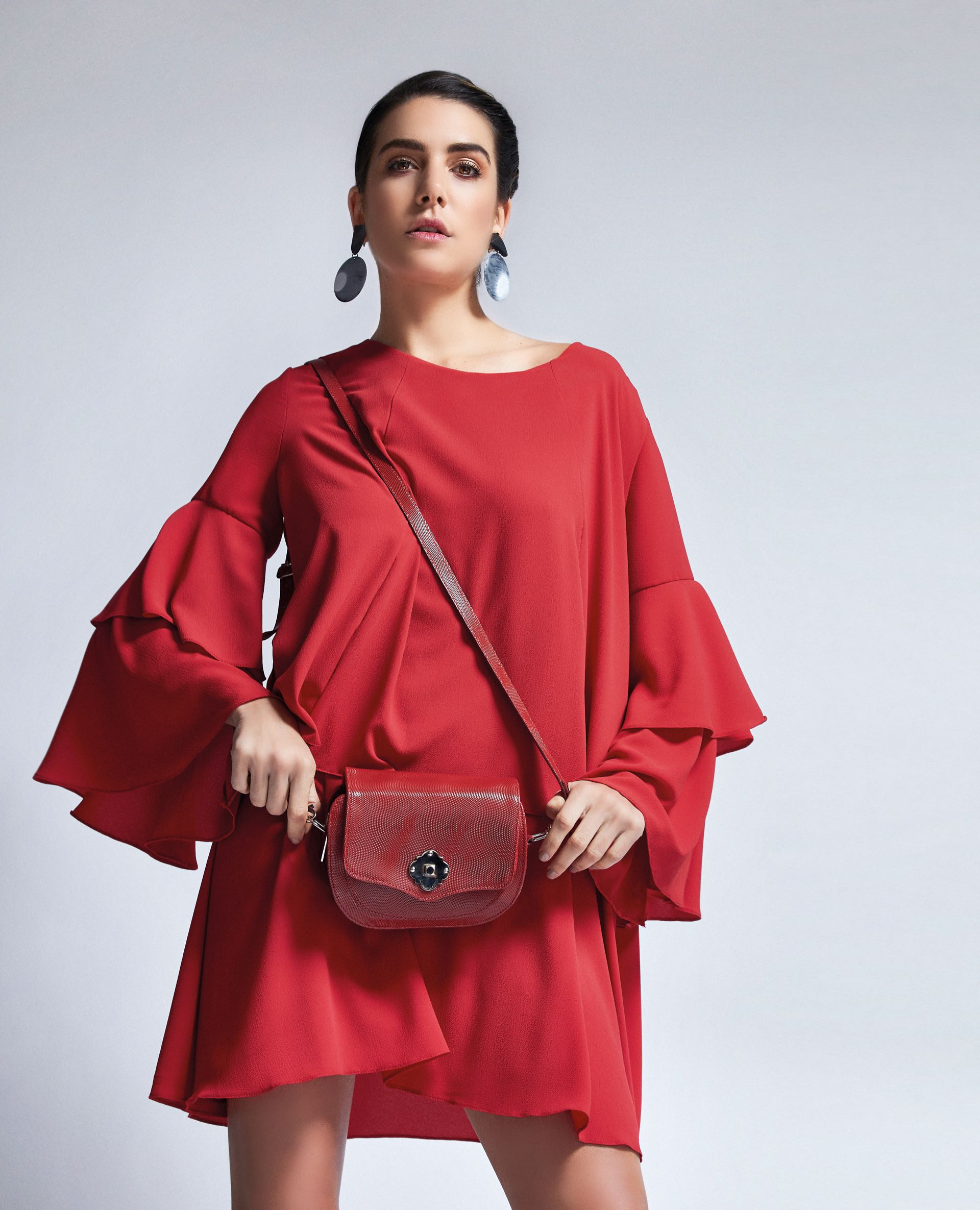 Vestido con volados en las mangas ($ 3.290, Becci), cartera de cuero ($ 2.880, Saverio Di Ricci) y aros nacarados (Gusmán). (Foto: Chino Toccalino/ Para Ti)