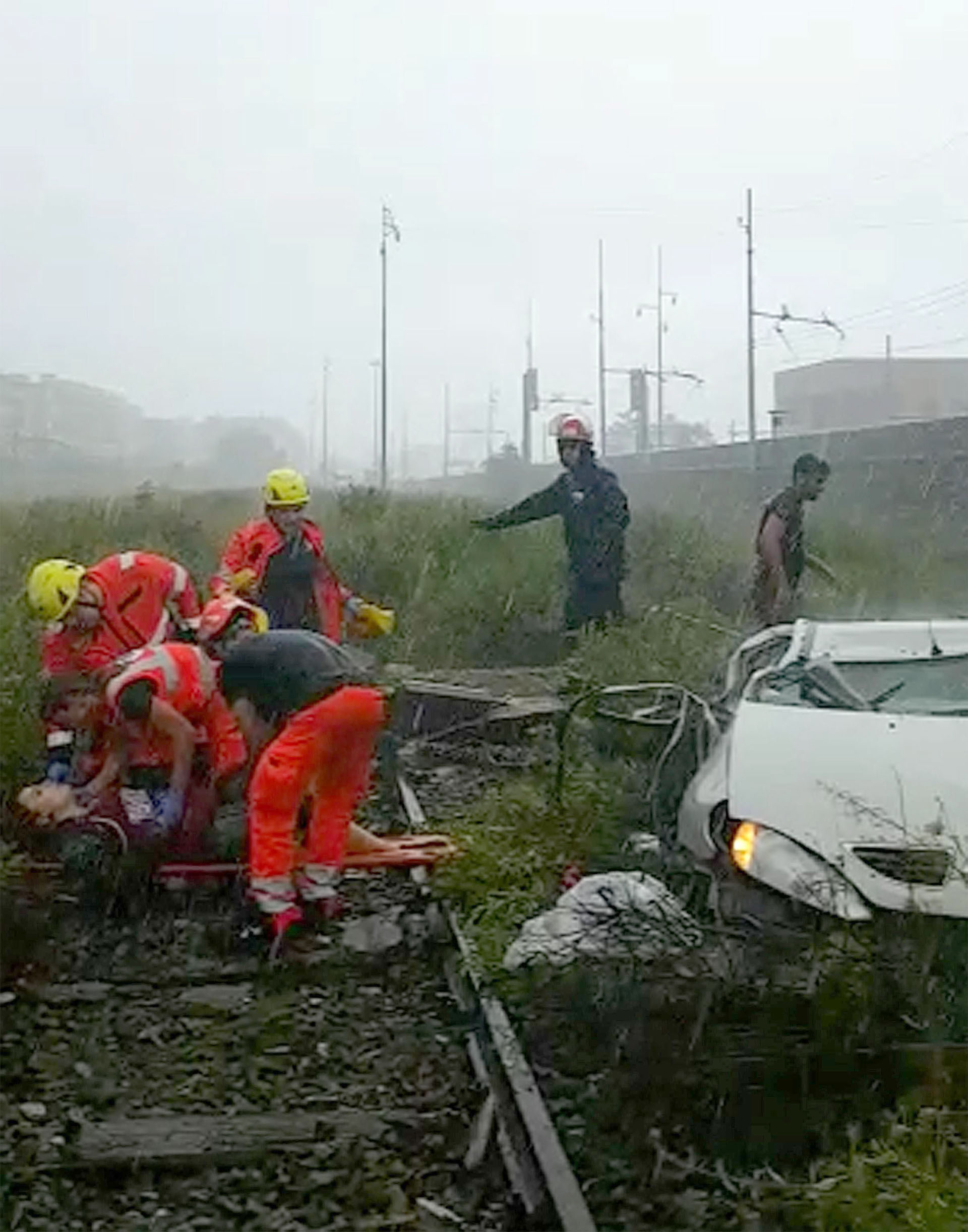 Varios miembros de los equipos de rescate atienden a una de las víctimas tras desplomarse un viaducto sobre la autopista A10 (EFE)