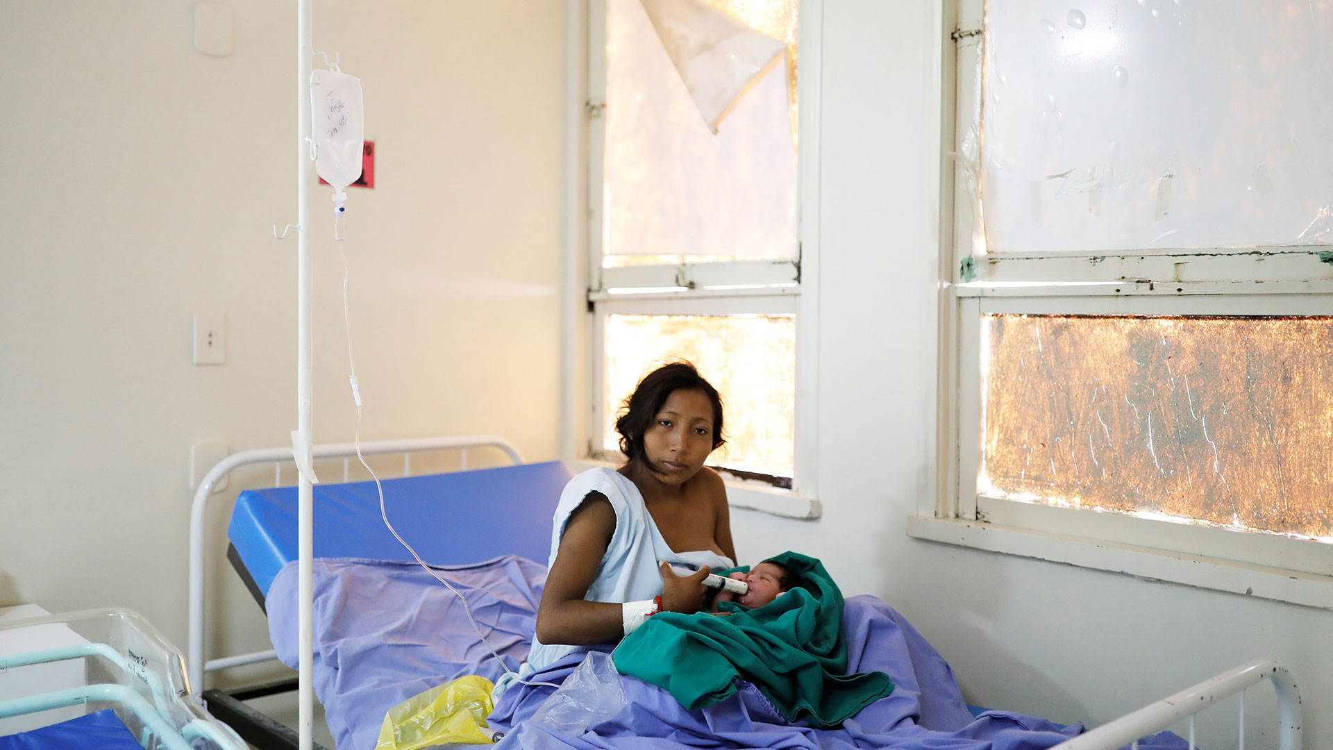 María Teresa López, de 20 años, indígena Warao del estado de Delta Amacuro, usa una jeringa para alimentar a su bebé Fabiola, de un día, en una maternidad en Boa Vista, estado de Roraima, Brasil, el 21 de agosto de 2018.(Reuters)