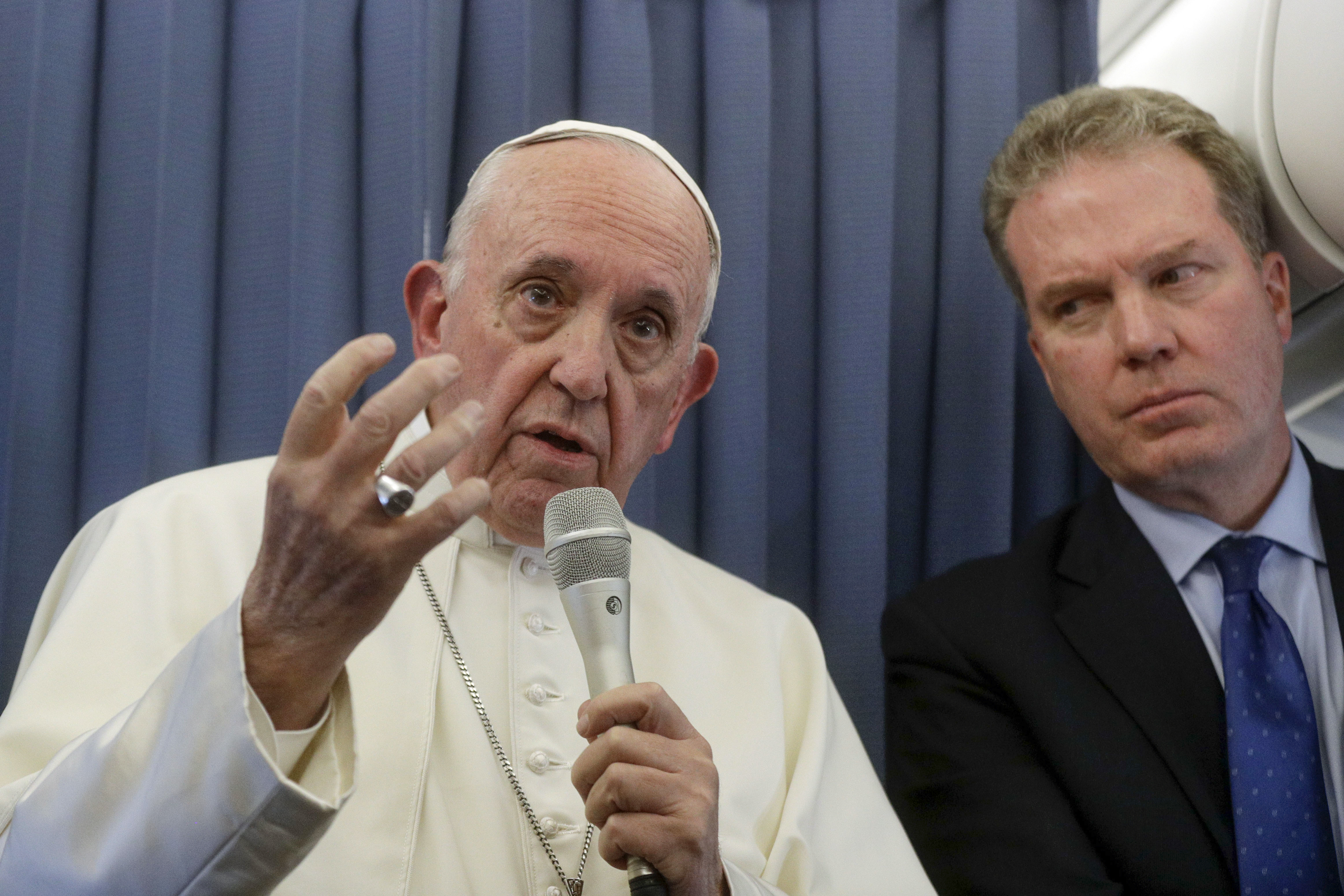 El papa Francisco junto con el jefe de la oficina de prensa del Vaticano, Greg Burke, durante la conferencia de prensa a bordo del avión que lo llevaba de vuelta a Roma desde Irlanda (AFP / Gregorio Borgia)