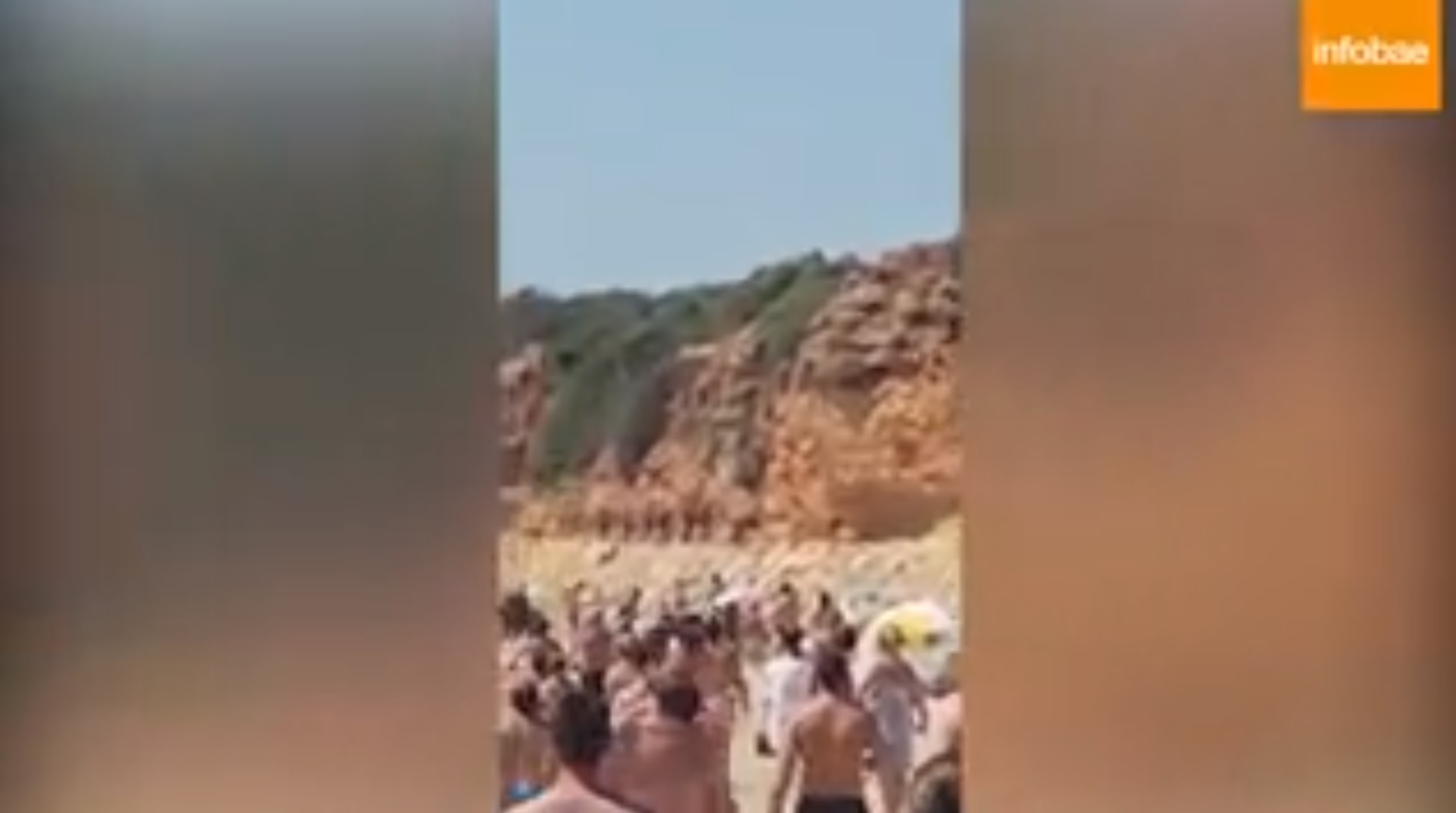Turistas observan el escape bordeando el acantilado