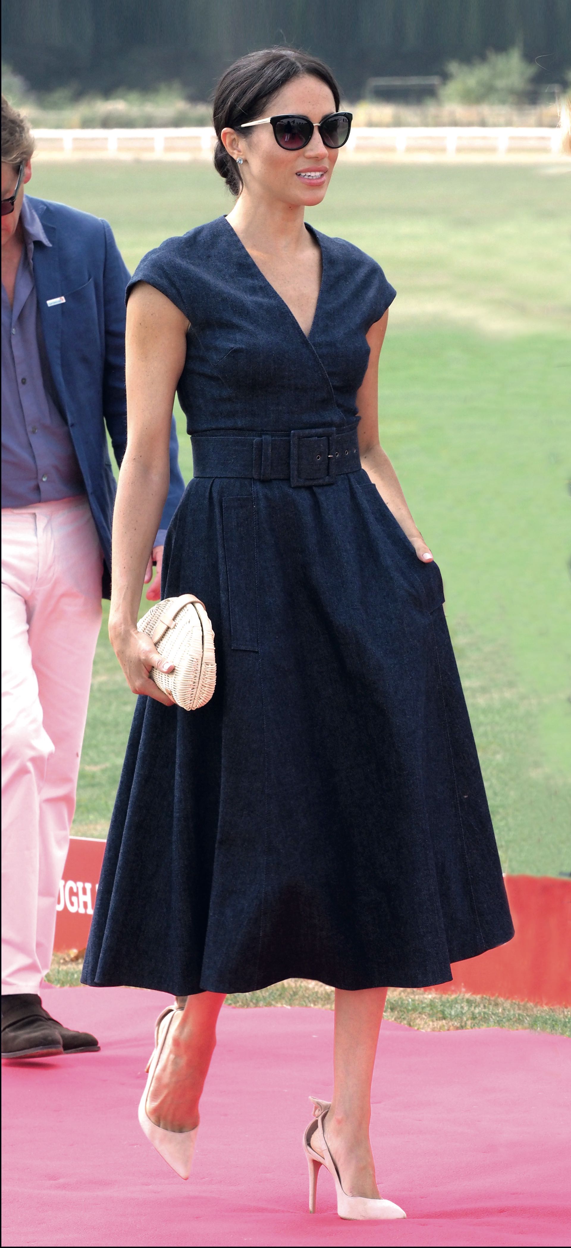 Meghan Markle estilo chica de campo, el 26 de julio en Berkshire. Para apoyar a Harry en un partido de polo a beneficio de Sentebale, su fundación, apostó a un vestido midi de jean, con cinturón importante de Carolina Herrera. Los combinó con stilettos nude de Aquazzura, clutch de ratán by J. Crew y lentes de sol Tom Ford. Se destacaron los aros de plata y topacio azul de la joyería Birks. Y el look se completó con su rodete desprolijo.