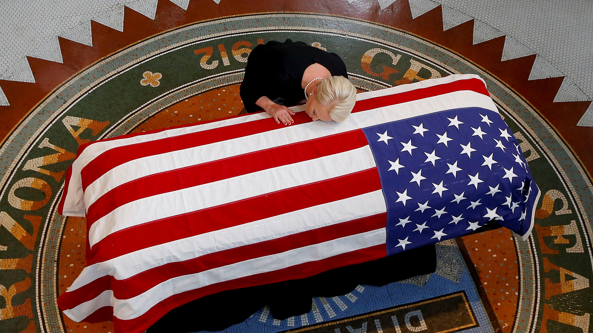 Cindy McCain, la viuda del senador John McCain, apoya su cabeza en el ataúd durante el funeral en el Capitolio de Arizona el 29 de agosto