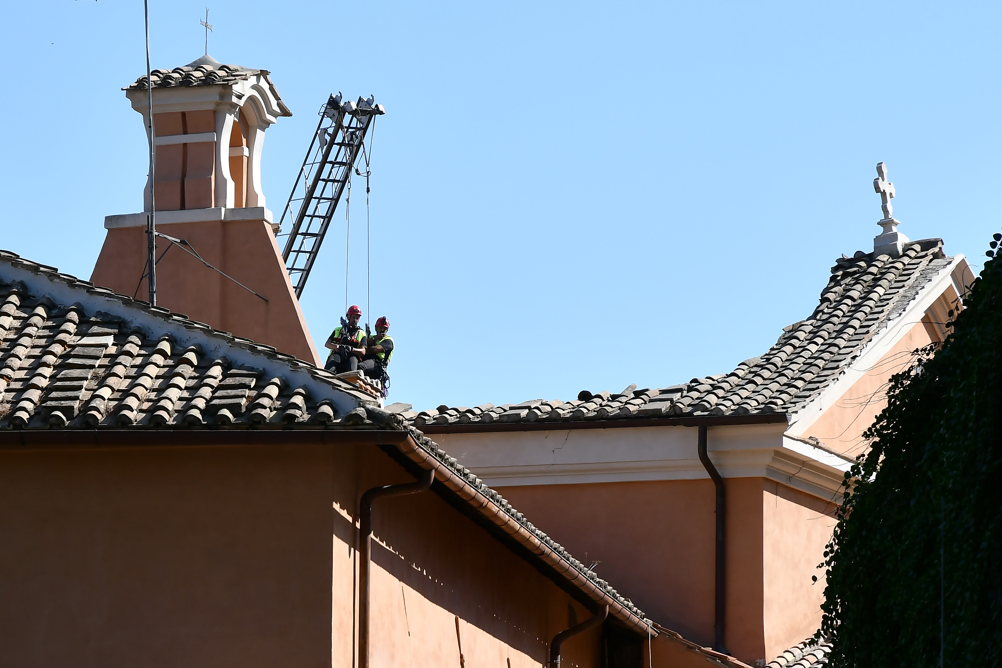 Bomberos trabajan en el techo de la iglesia (AFP / Alberto PIZZOLI)