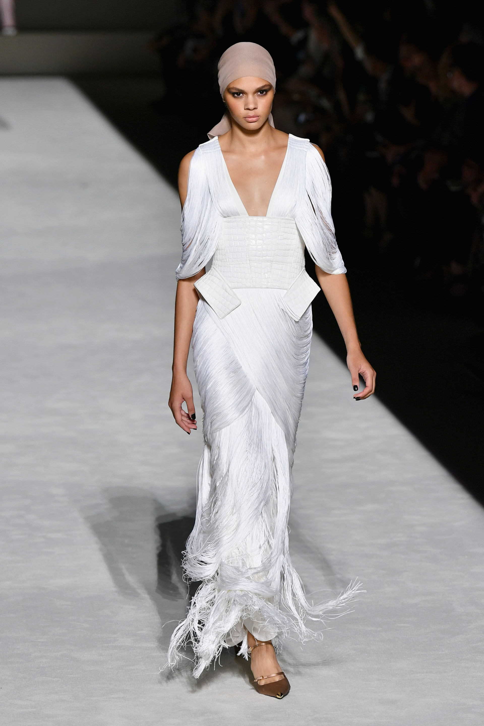 La tendencia de los flecos volvió a tocar puerta de la mano de Tom Ford. Varios de los diseños presentados en la pasarela contaron con flecos. En vestidos, faldas y blusas. En la foto, un vestido blanco hielo con flecos entrelazados y detalles de cuero blanco.