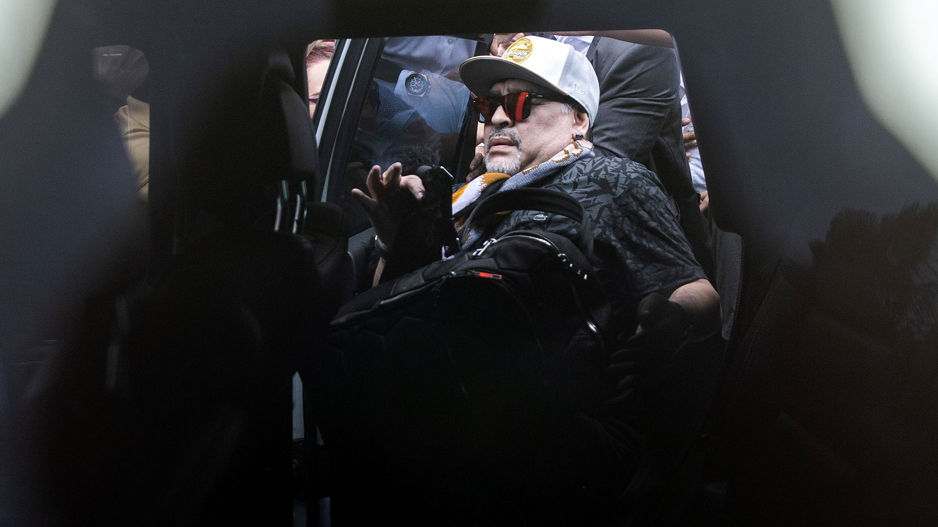 Diego Maradona ingresa a un automóvil a su llegada al aeropuerto internacional de Culiacán, estado de Sinaloa, México. Fue rodeado por cientos de fanáticos (AFP)