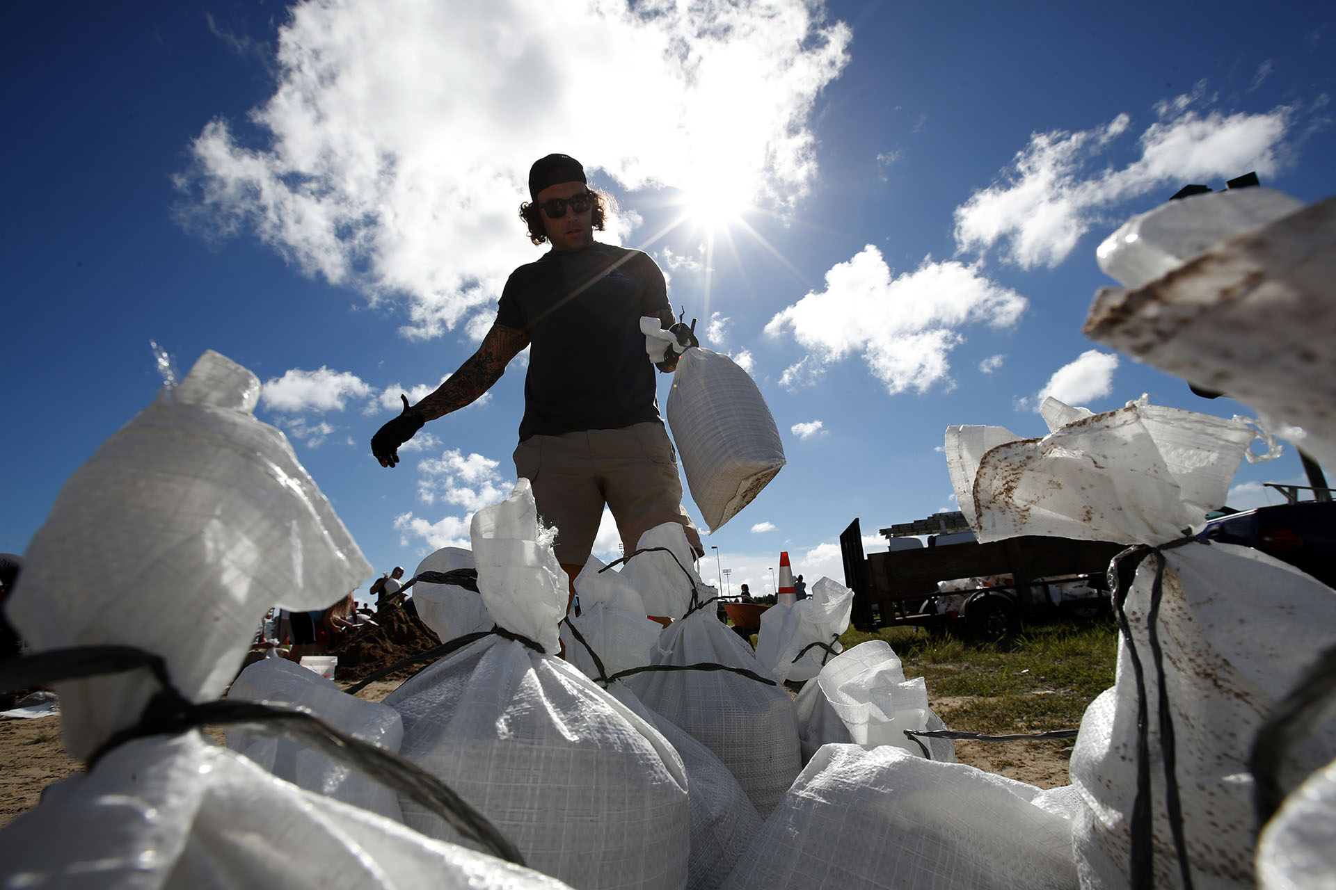 Un residente de Virginia Beach, Virginia, carga un saco de arena antes de llevarlo a su camioneta (AP Photo/Alex Brandon)