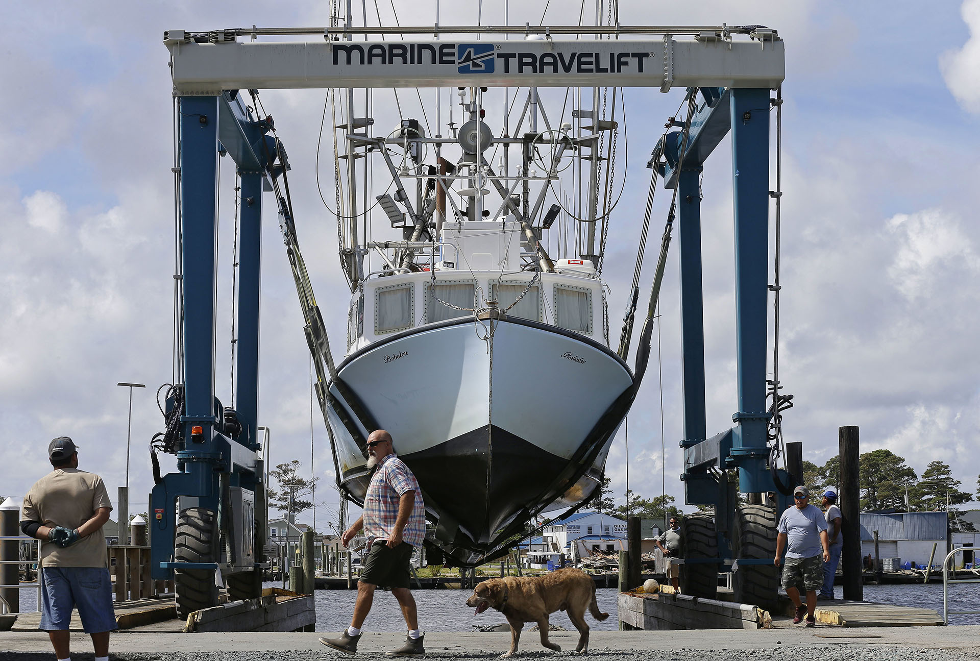 Los trabajadores sacan barcos fuera del agua en el puerto de Wanchese, Carolina del Norte (AP Photo/Gerry Broome)