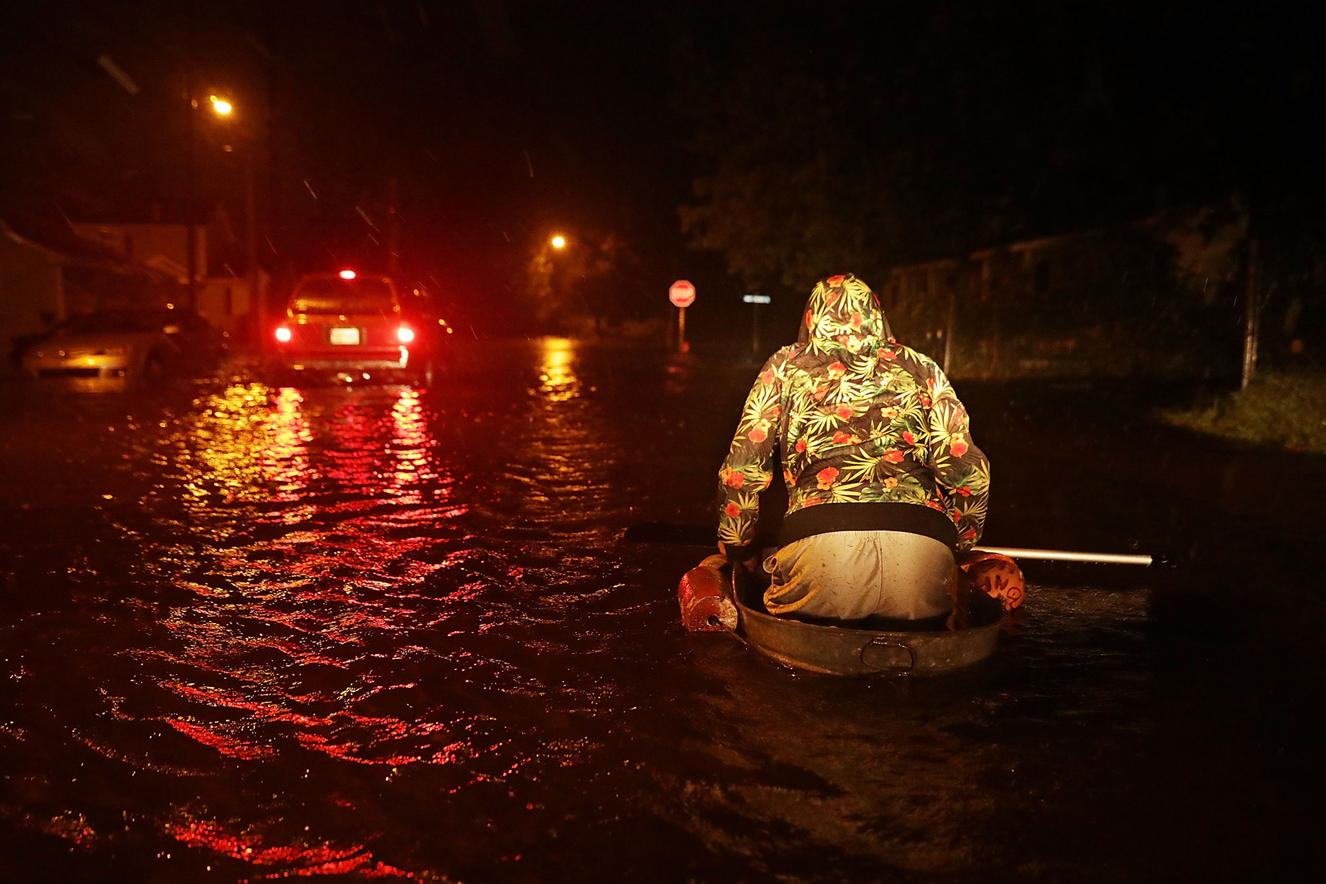 Un hombre llamado Michael Nelson navega en un bote improvisado hecho de una bañera de metal y flotadores de pesca después de que el río Neuse inundara su calle durante el huracán Florence.