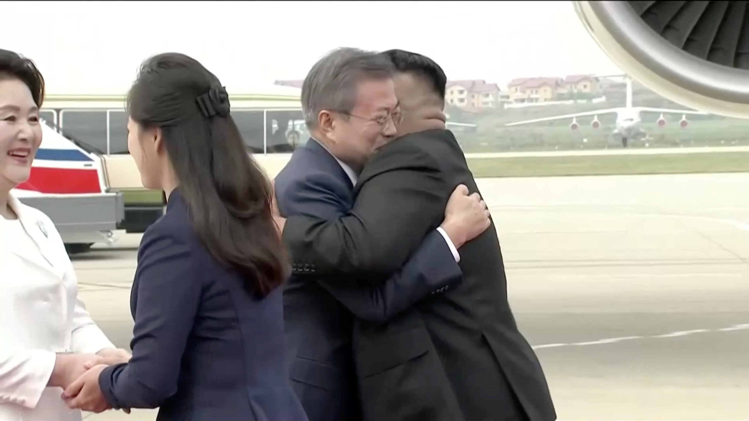 Los dos dirigentes se abrazaron después de que Moon bajara del avión. Acompañados por sus esposas, bromearon durante unos minutos, mientras cientos de personas agitaban banderas norcoreanas y emblemas de la unificación