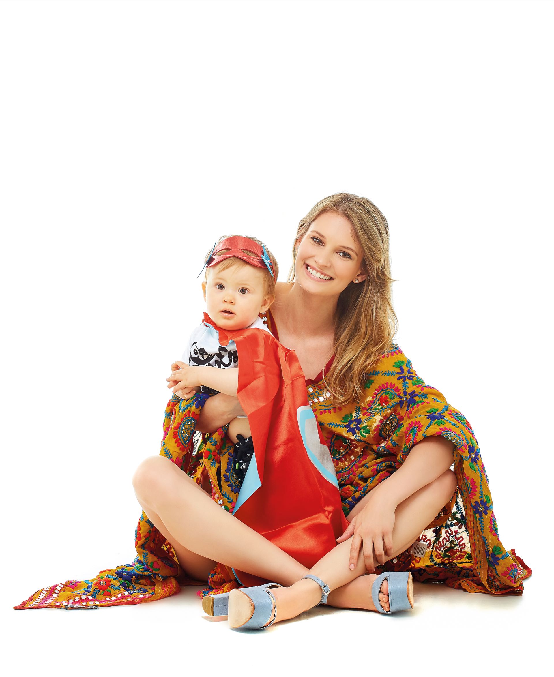 Betu: poncho bordado con espejitos (Var’s) y sandalias de gamuza ($ 5.395, The Bag Belt). Bauti: remera con estampa, bermudas de gabardina y disfraz de superhéroe ($ 599, $ 1.499 y $ 715, Grisino).