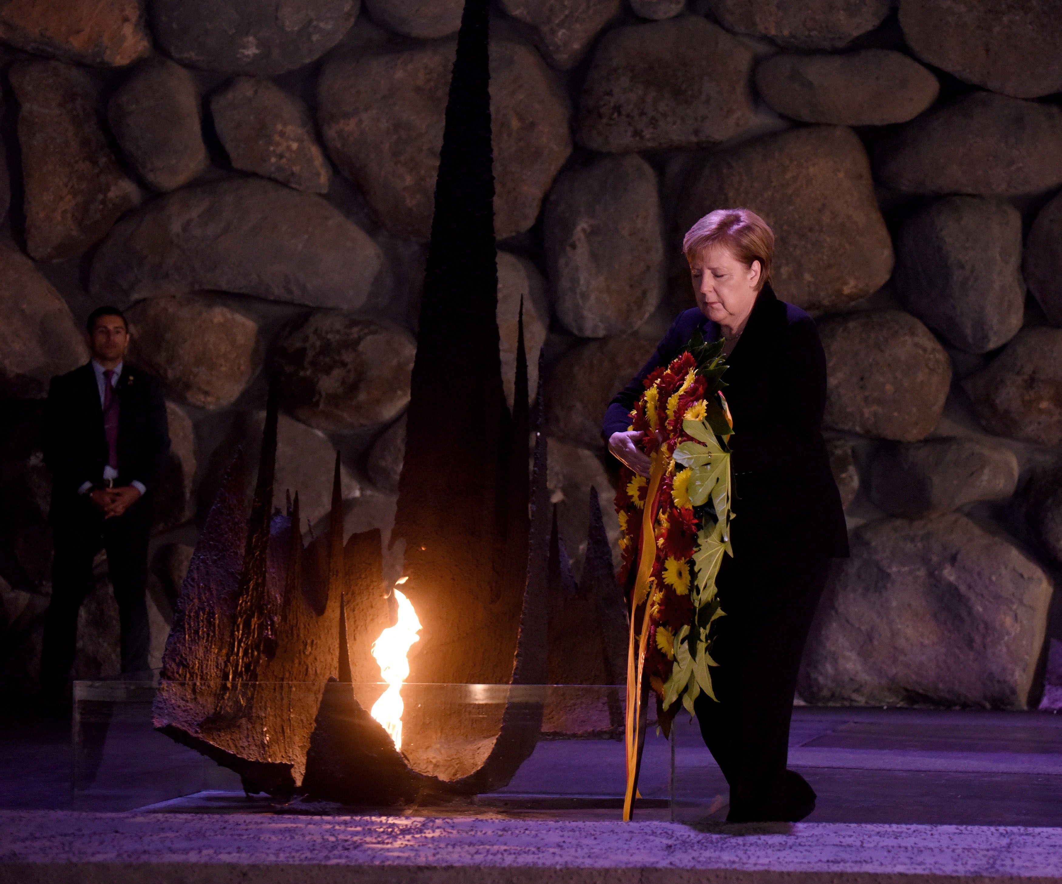 La canciller alemana, Angela Merkel, hace una ofrenda floral en la Sala del Recuerdo del Museo del Holocausto Yad Vashem en Jerusalén, Israel. (EFE/ Debbie Hill)