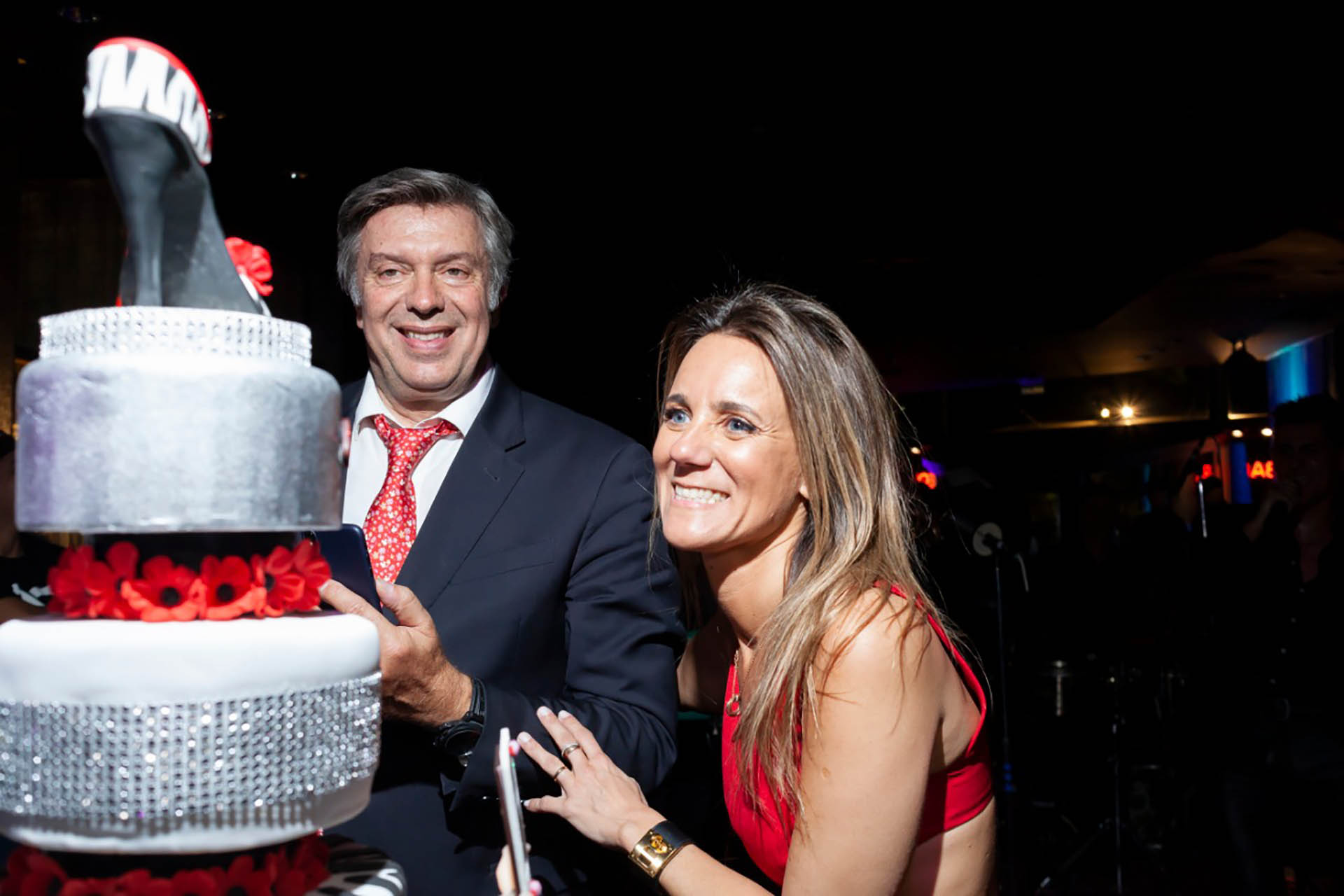 La pareja frente a la torta de tres pisos con los que la doctora festejó los 40