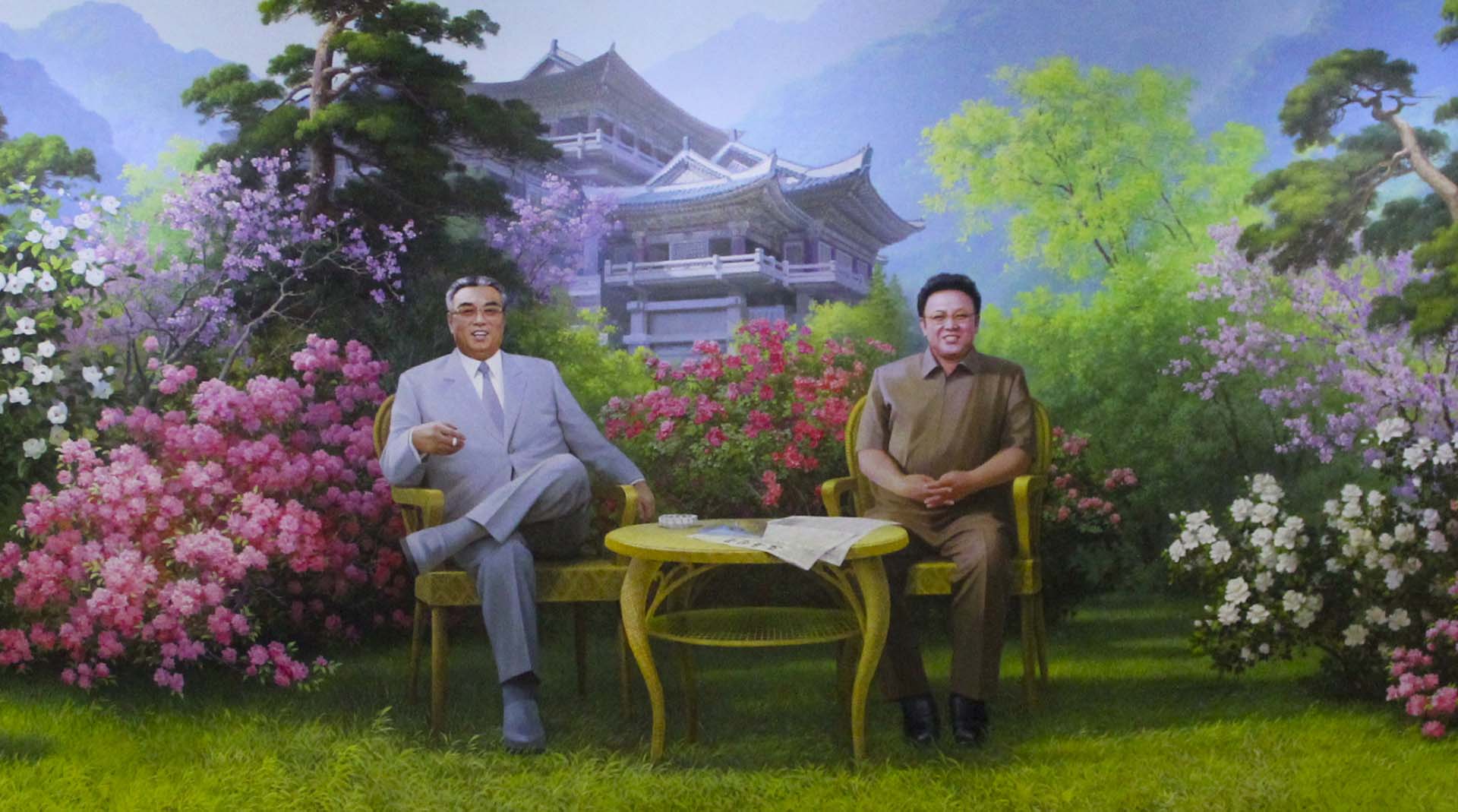 Al otro lado de las puertas metálicas del hotel Chongchon, en el interior de Corea del Norte, nos esperaban las efigies de Kim Il Sung, vestido con su traje gris de rutina, y Kim Jong Il, con su uniforme amarronado engañosamente militar, sonriendo desde un mural atornillado en la pared principal de la recepción. Las azaleas que rodeaban a los líderes y perfumaban la hora del té se reflejaban en el piso de cerámicos brillantes como en un estanque. No eran las únicas flores que gustaban a los líderes. La orquídea púrpura y la begonia roja son las más famosas y adoradas de Corea del Norte, donde se conocen con los nombres botánicos personalísimos de Kimilsungia y Kimjongilia: la flor de Kim Il Sung, la flor de Kim Jong Il