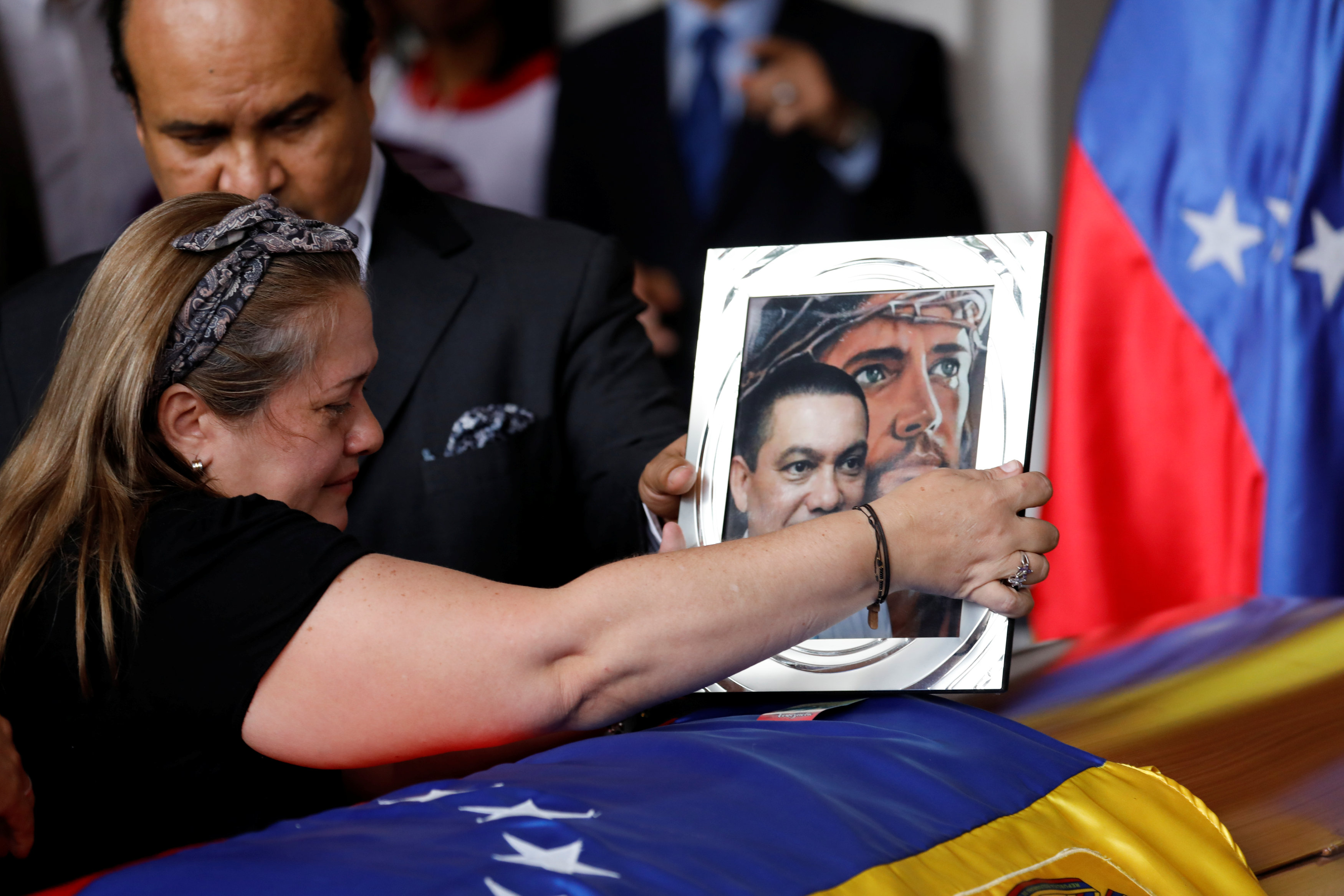 Luz Albán pone una foto sobre el ataúd de su hermano Fernando Alban durante una ceremonia en la Asamblea Nacional de Caracas (REUTERS/Marco Bello)