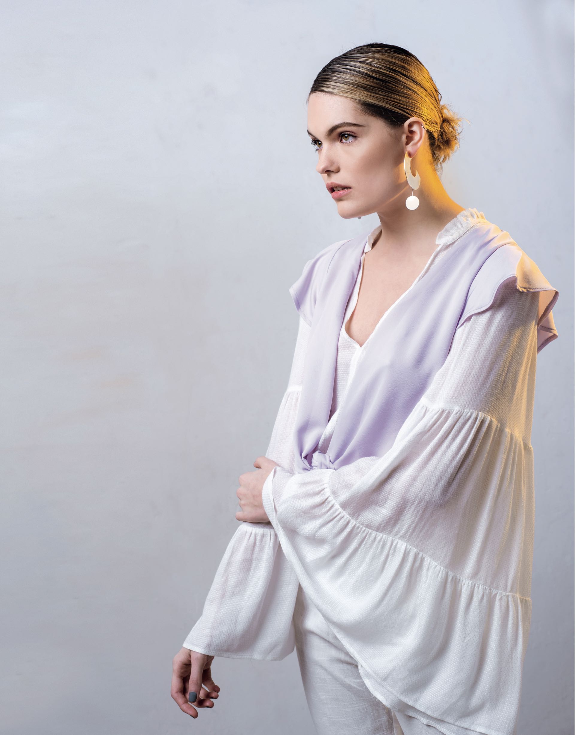 Camisa sin mangas con nudo ($ 1.180, Zhoue), por debajo, blusa con mangas acampanadas (aprox. $ 2.500, India Style), aros largos ($ 1.890, Las Juanas Night) y aros en medialuna ($ 390, Dolores Iguacel). (Foto: Maia Croizet/ Para Ti)