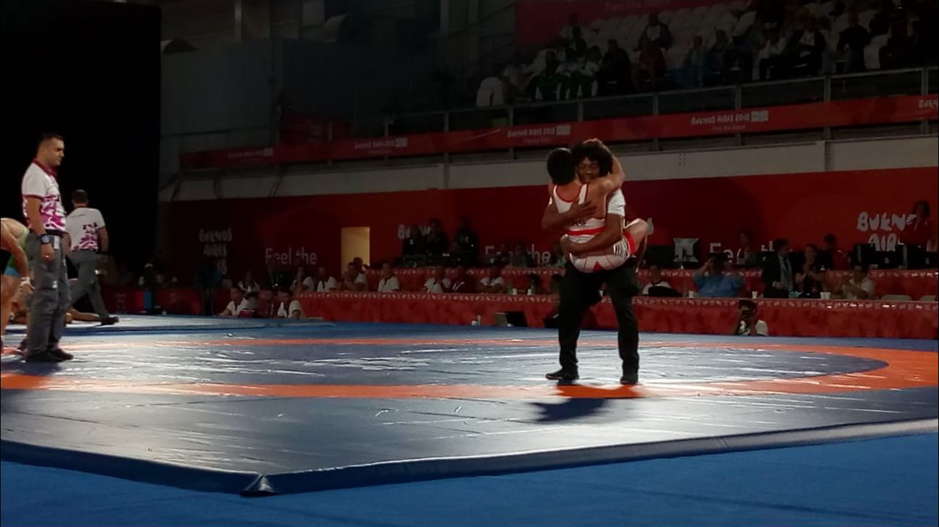 David Almendra celebra su triunfo en semifinales de lucha libre con su profesor cubano