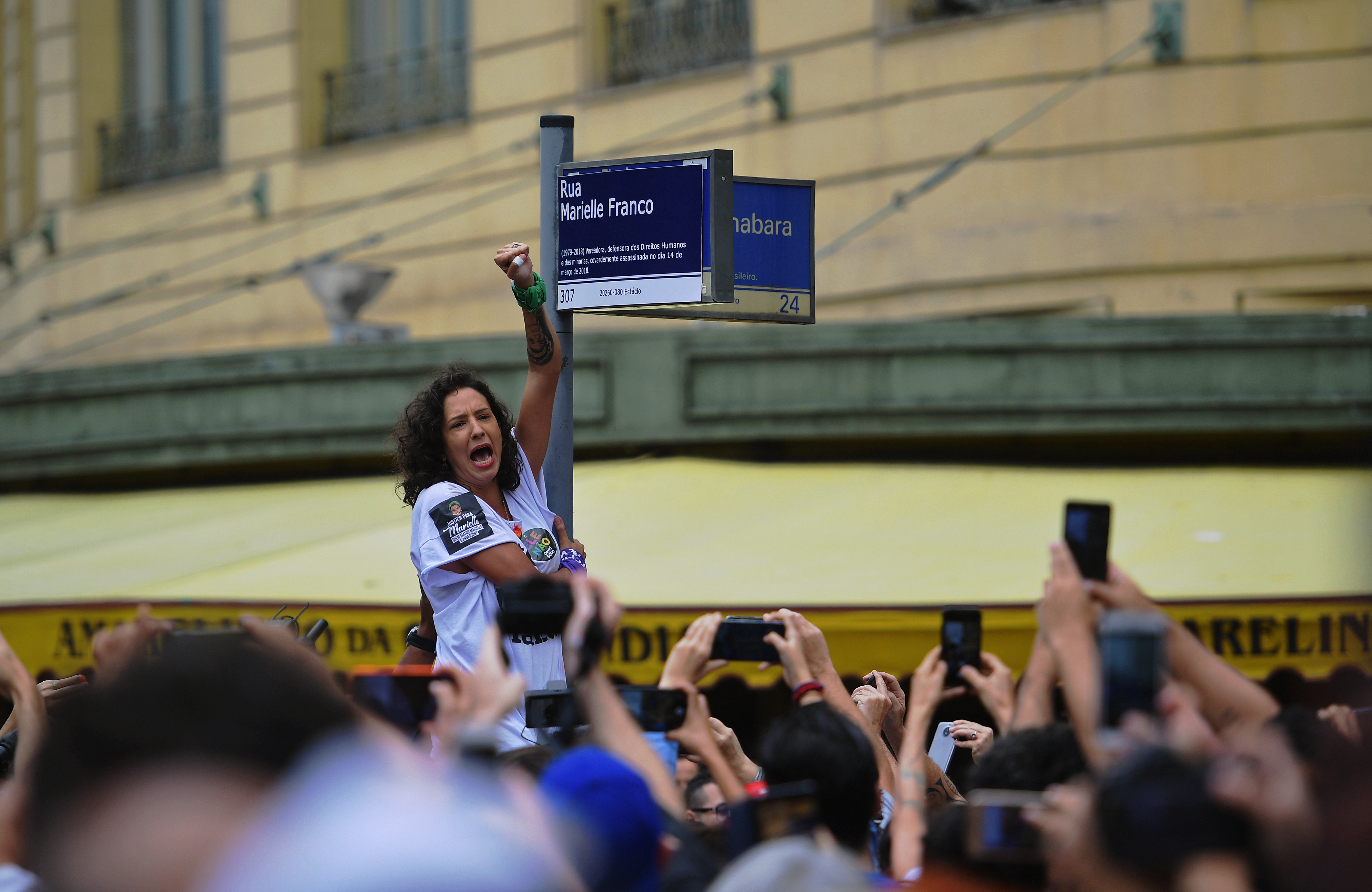 Teresa Benicio, viuda de Mariella Franco, reemplaza la placa con el nombre de la concejal asesinada (CARL DE SOUZA / AFP)
