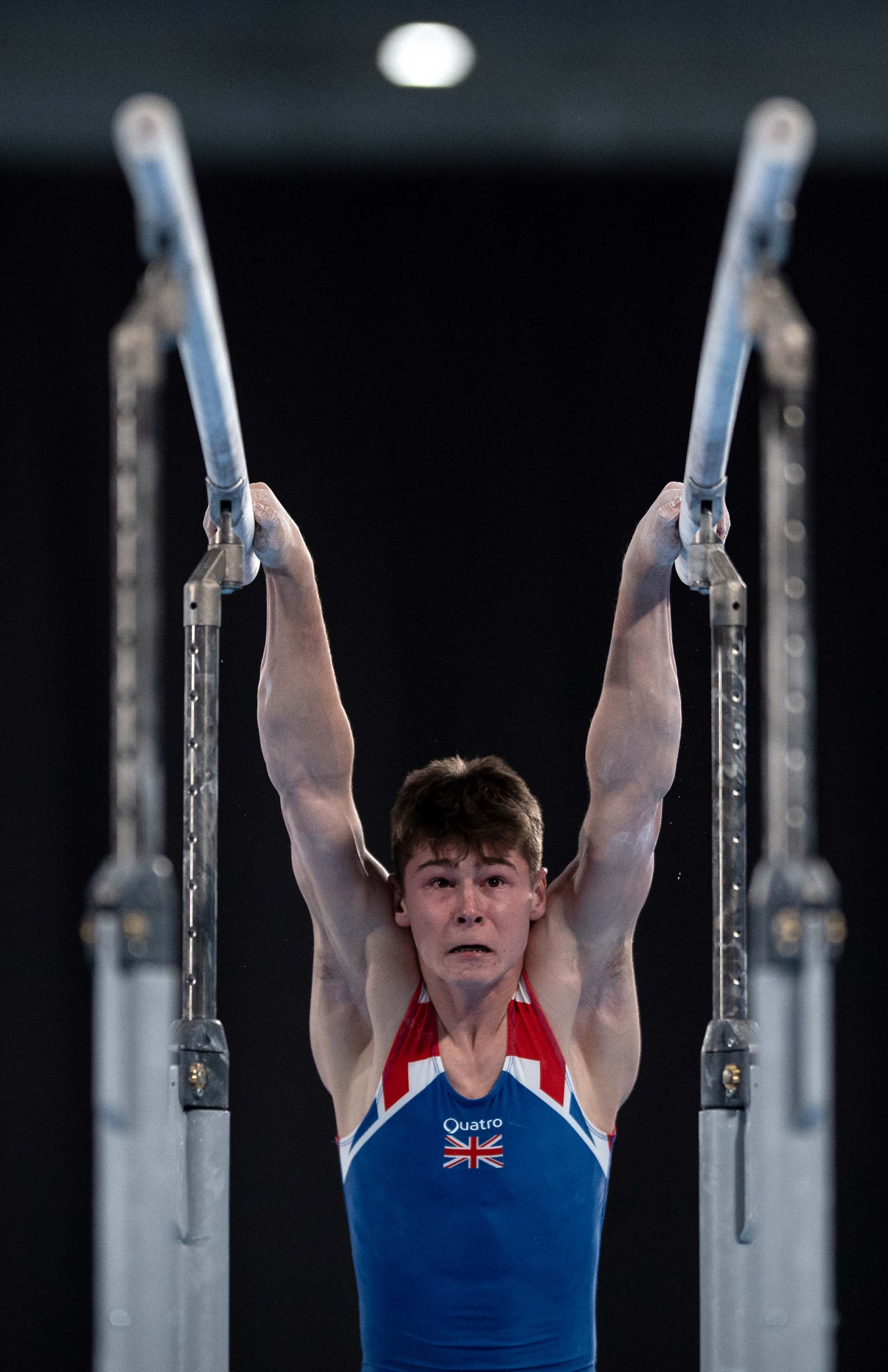 El británico Adam Tobin expone su sacrificio en la prueba de barras paralelas de gimnasia (Foto: Joel MARKLUND / AFP)