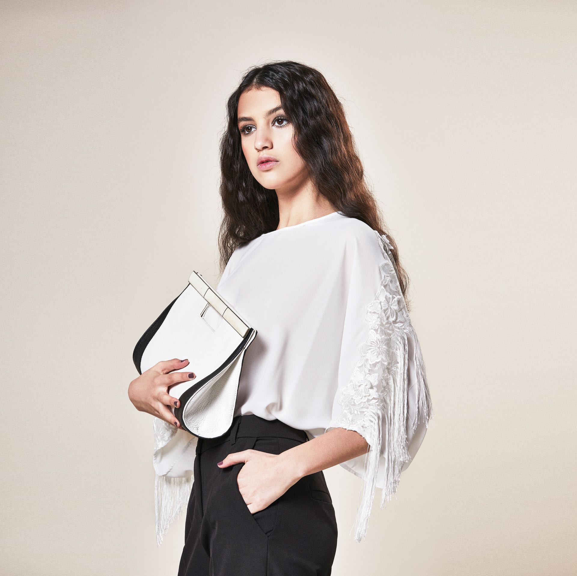 Blusa de gasa con encaje y flecos ($ 6.000, Rafael Garófalo), pantalón sastre($ 2.400, Ossira) y clutch de cuero y nácar (Casta by Analía).