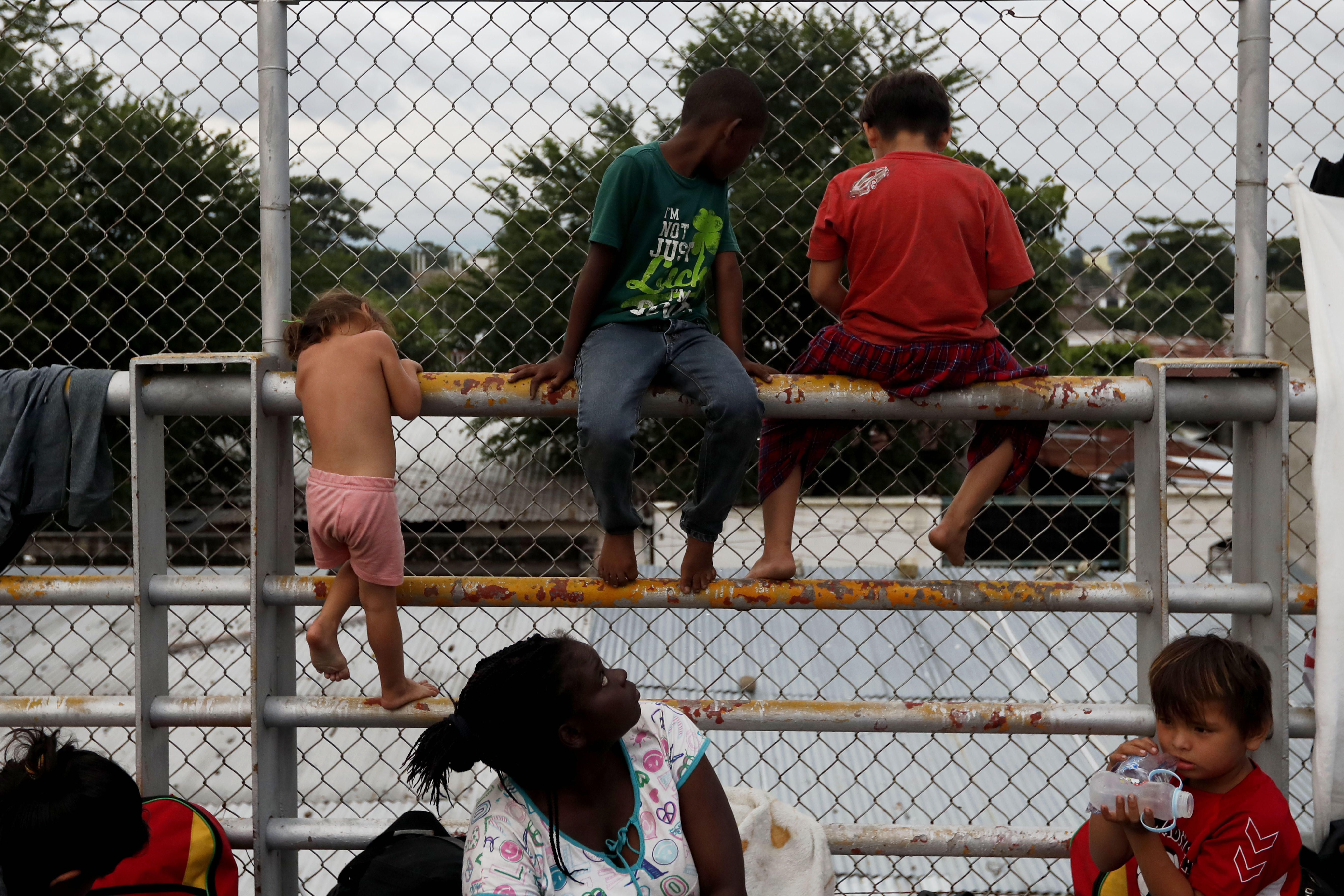 Grupos de migrantes hondureños esperan a poder entrar en México, en el puente que separa los dos países. (EFE/Esteban Biba)
