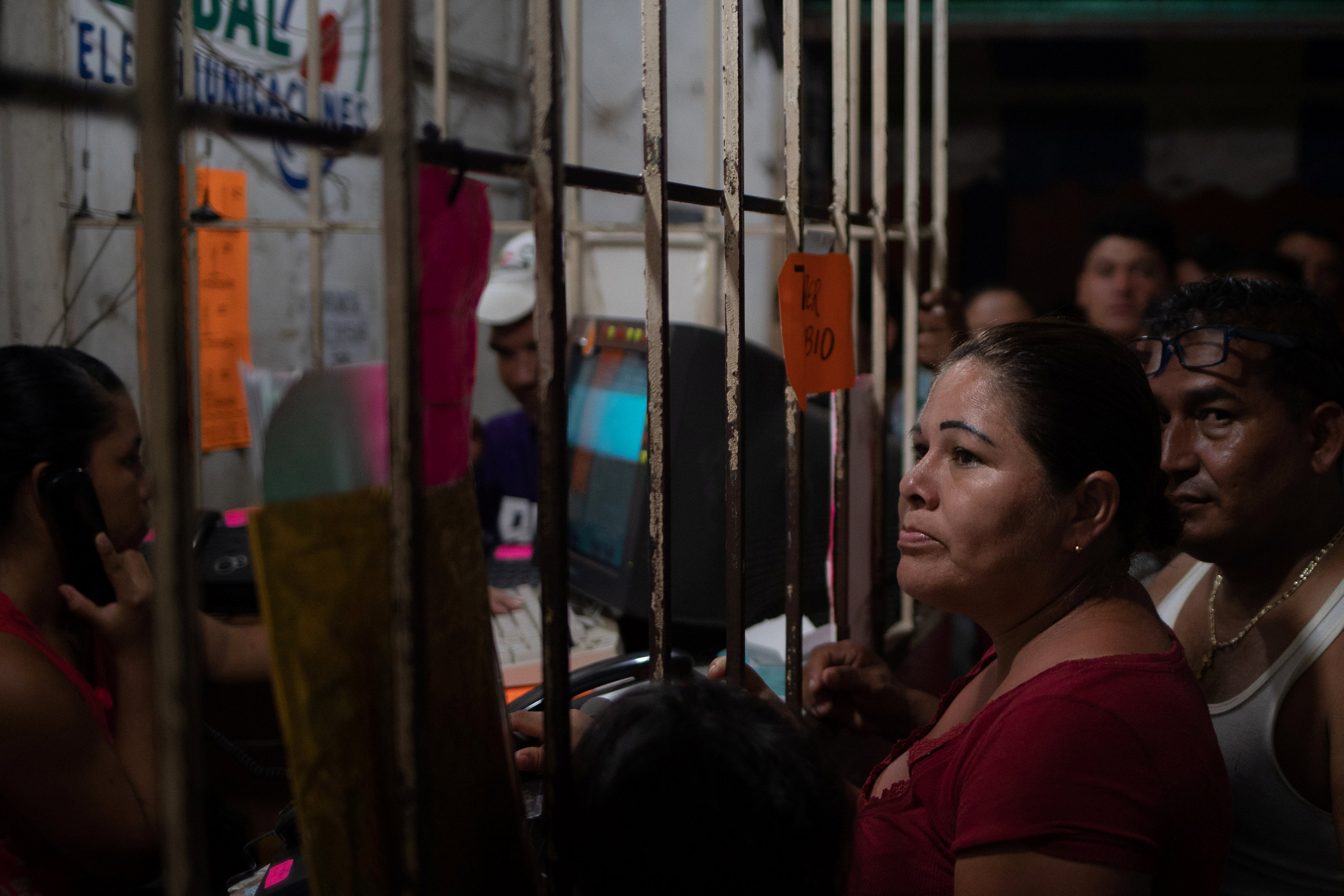 Migrantes centroamericanos esperan para llamar a sus familiares desde una tienda de teléfonos en Huixtla, Mexico (REUTERS/Adrees Latif)