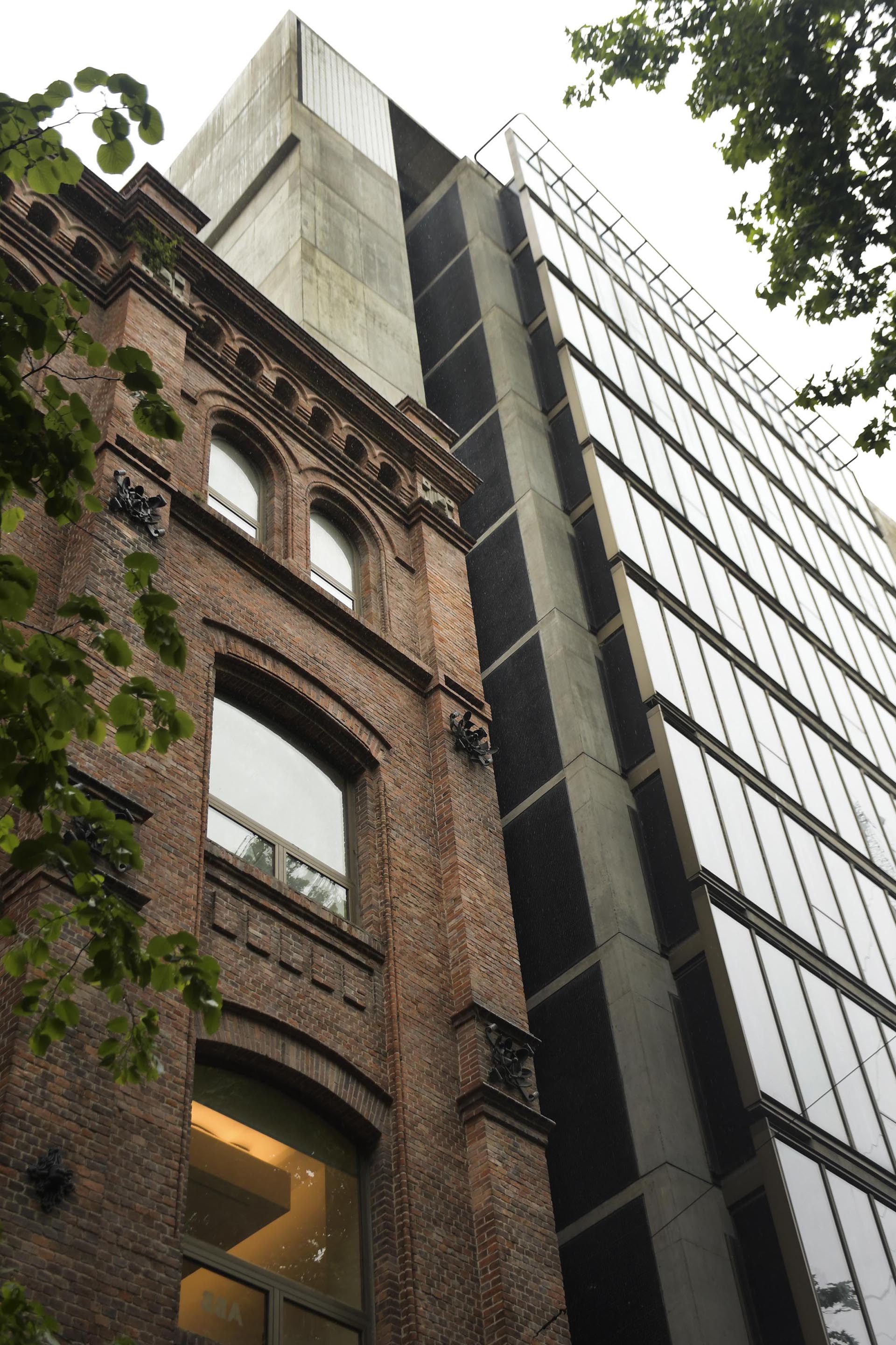 El edificio de estilo industrial inglés fue puesta en valor para conformar junto con la esquina de vidrio y hormigón, un edificio de oficinas recientemente inaugurado.
