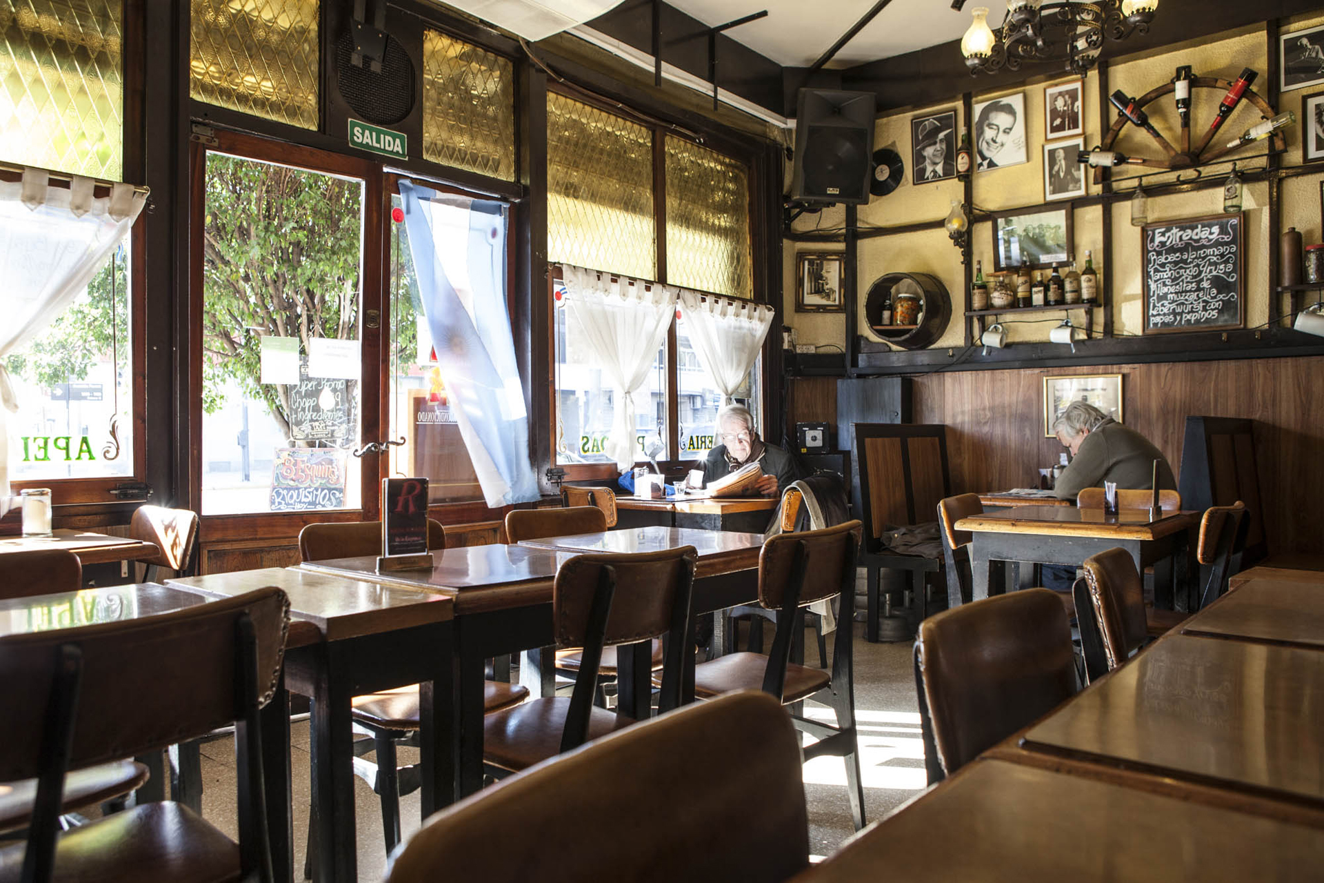 El interior del café está decorado con botellas y portaretratos de personalidades de la música y sobre todo del tango