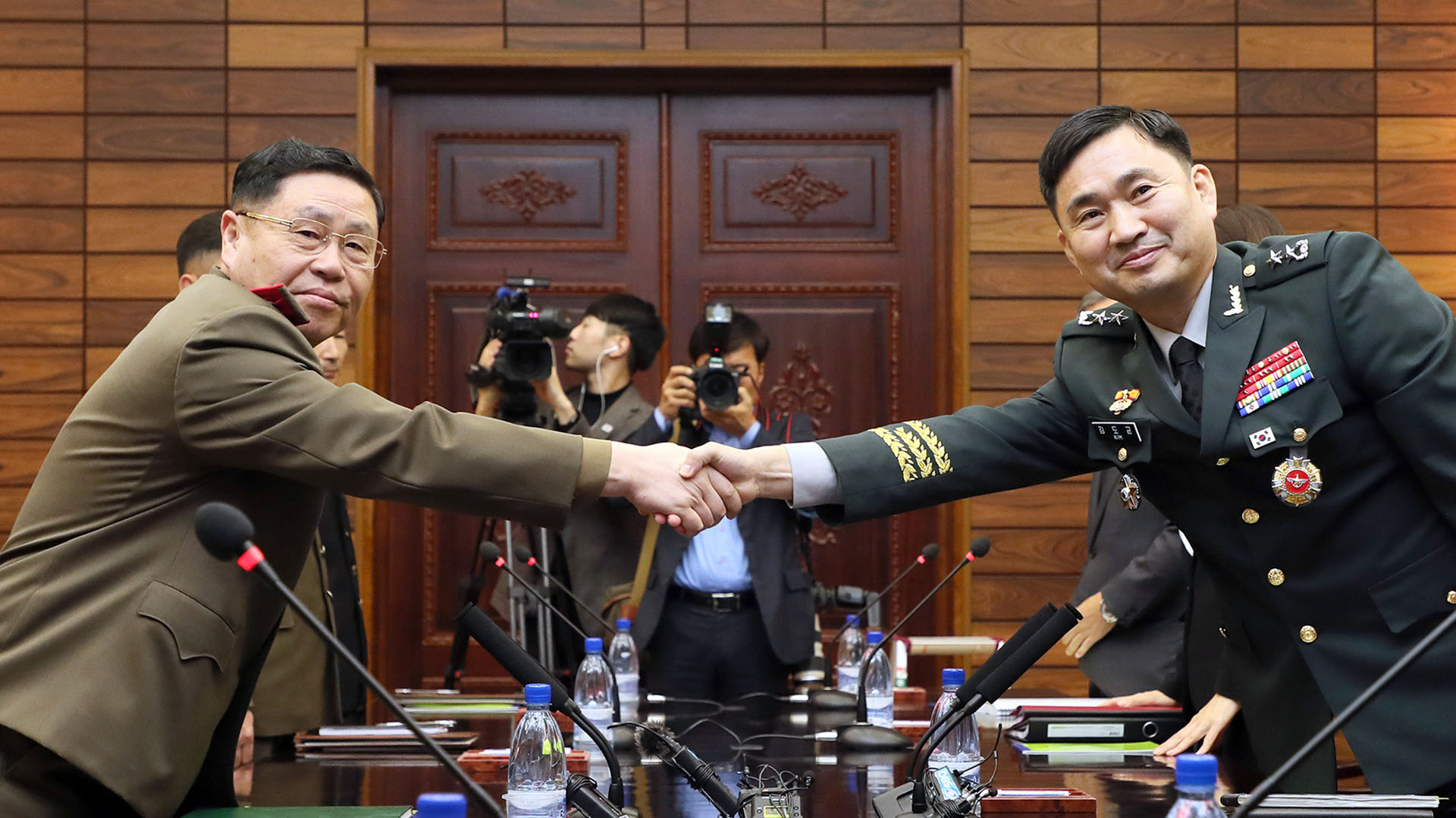 El general Kim do-Gyun (Corea del Sur) estrechando la mano con su homólogo norcoreano Un San durante sus conversaciones militares de nivel general en el lado del norte de la aldea de la tregua de Panmunjom en la zona desmilitarizada (AFP PHOTO / South Korean Defence Ministry)