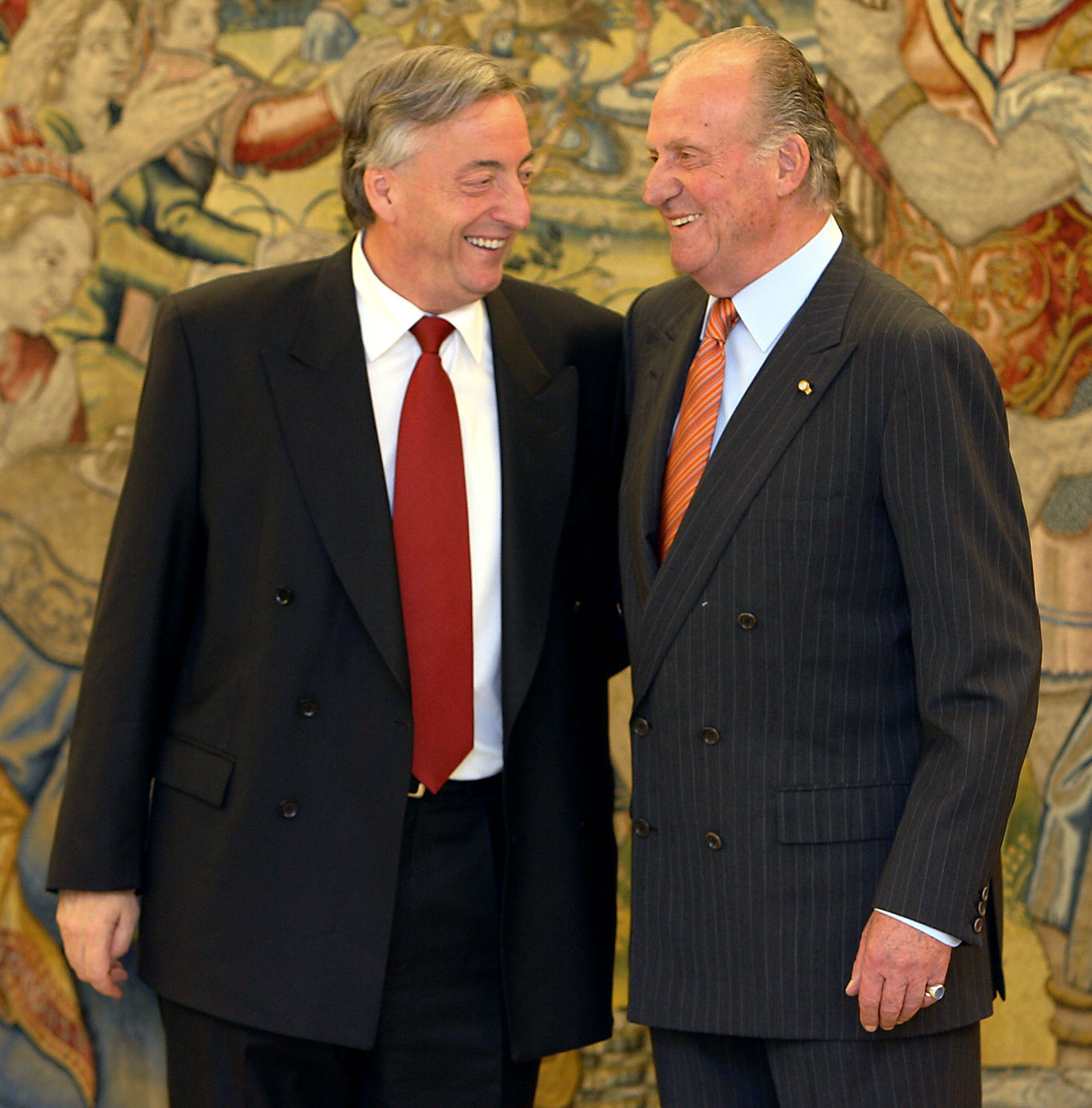 El rey Juan Carlos (R) de España y el presidente Néstor Kirchner disfrutan de una broma a su llegada al Palacio de la Zarzuela en Madrid, el 21 de junio de 2006.
