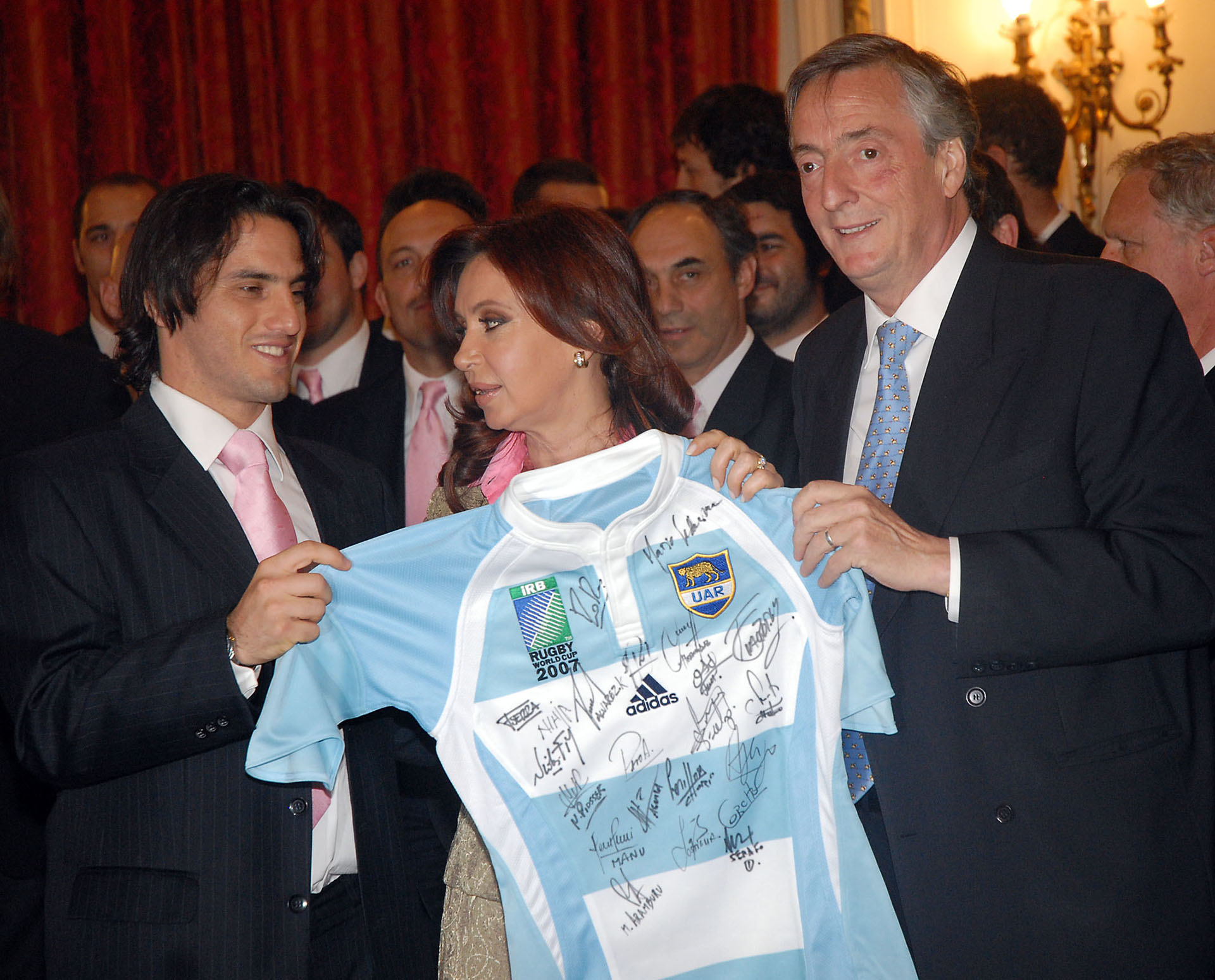 El presidente Néstor Kirchner, la senadora Cristina Fernández de Kirchner y el medio scrum Agustín Pichot con una camiseta autografiada de los Pumas durante la visita del seleccionado argentino de rugby a la Casa de Gobierno.