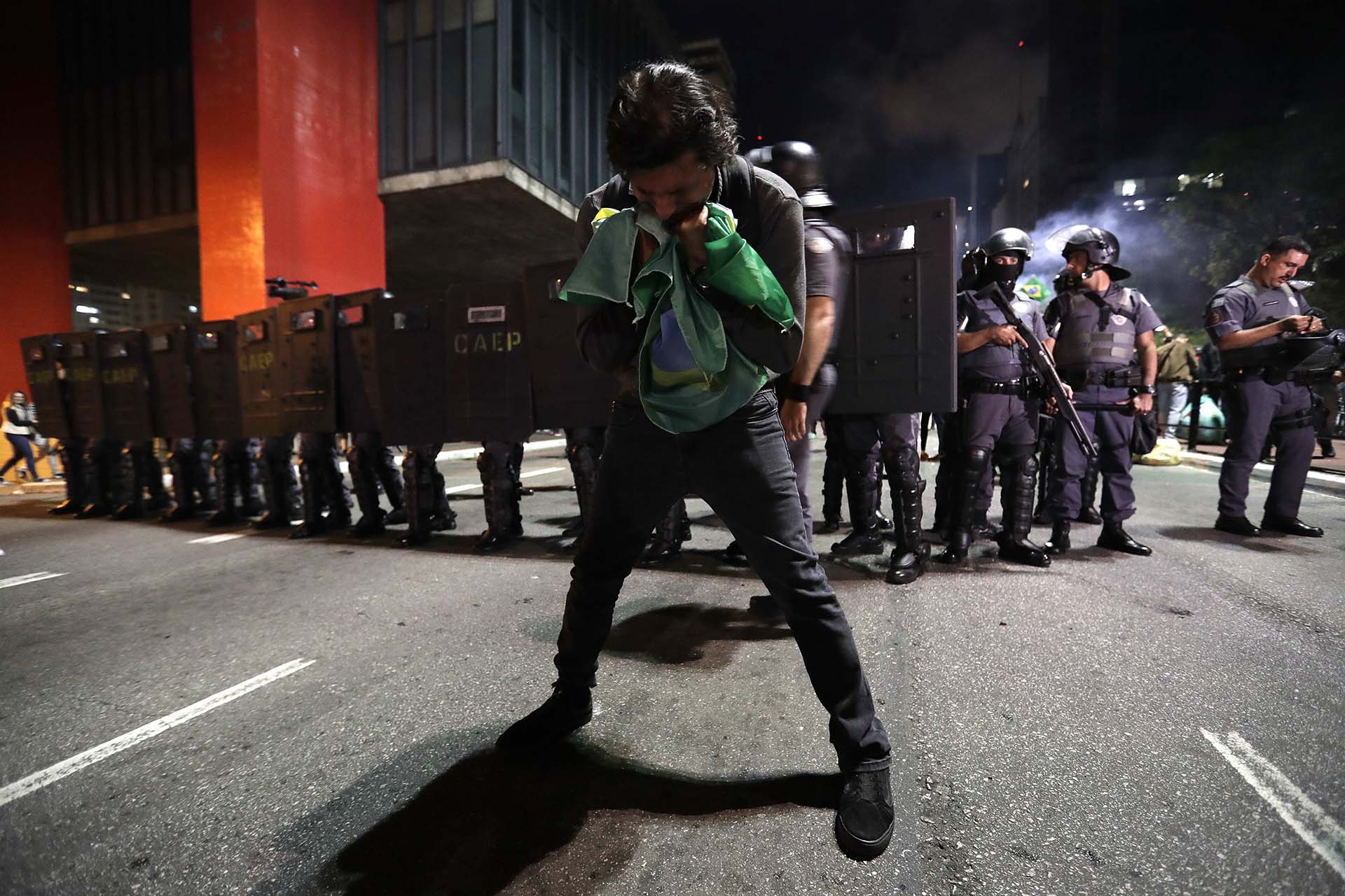 Un hombre besa la bandera de Brasil en medio de los festejos (Reuters y EFE)