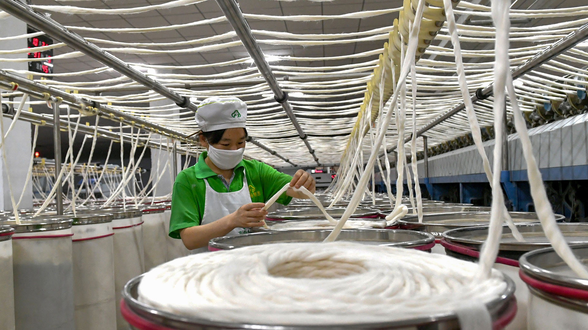 Un empleado trabaja en una fábrica del textil en el Condado de Xiayi en Shangqiu (Photo by STR / AFP) / China OUT