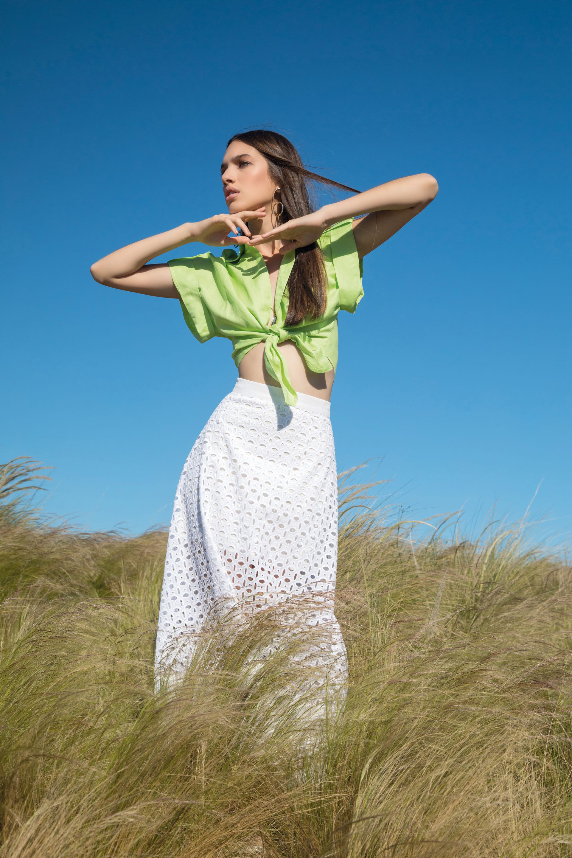 Camisa de lino con lazo y falda midi de broderie (DOT Store), collar semilargo con cadena y dijes y aros con eslabones de argollas irregulares ($ 1.125 y $ 900, Uma).