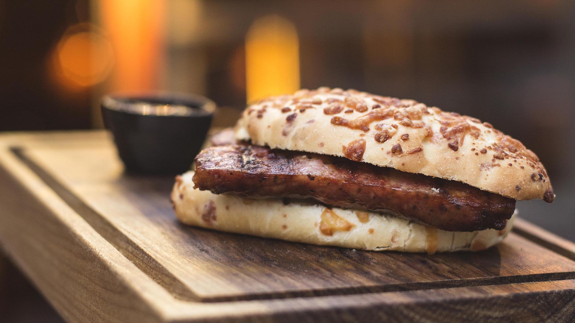 Es un sándwich de chorizo casero en pan de queso con dip de salsa criolla o chimichurri